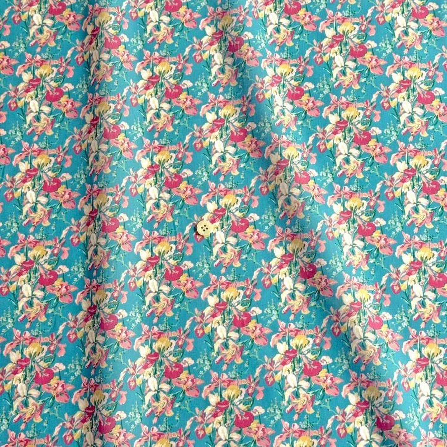 a fabric with a repeating floral pattern in shades of pink, yellow, and green. The pattern is vibrant and colorful, creating a lively and cheerful visual effect.