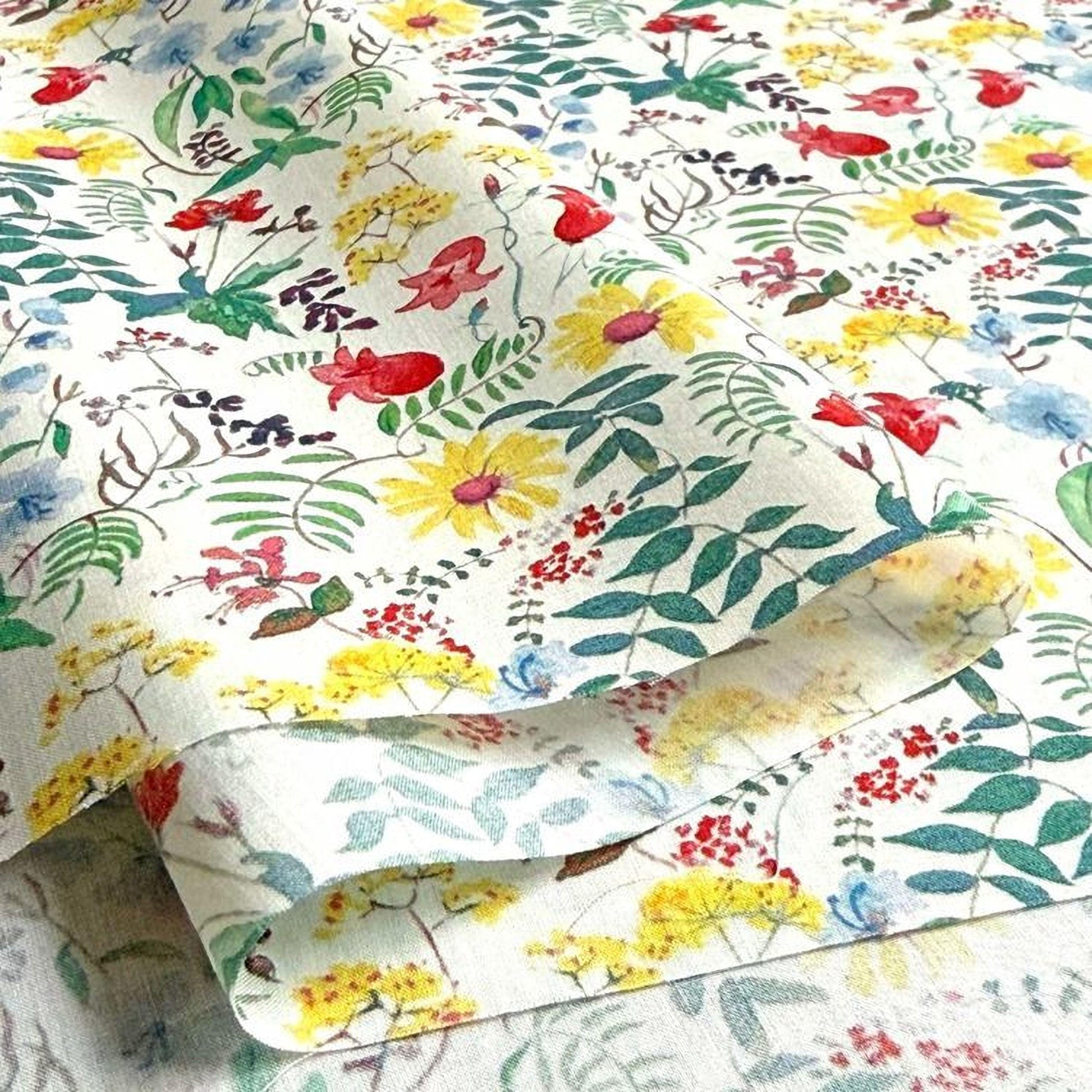 a close-up view of a fabric with a vibrant floral pattern. The fabric is predominantly white, adorned with a variety of colorful flowers and leaves in shades of red, yellow, and green. The pattern is intricate and detailed, showcasing the craftsmanship of the fabric.