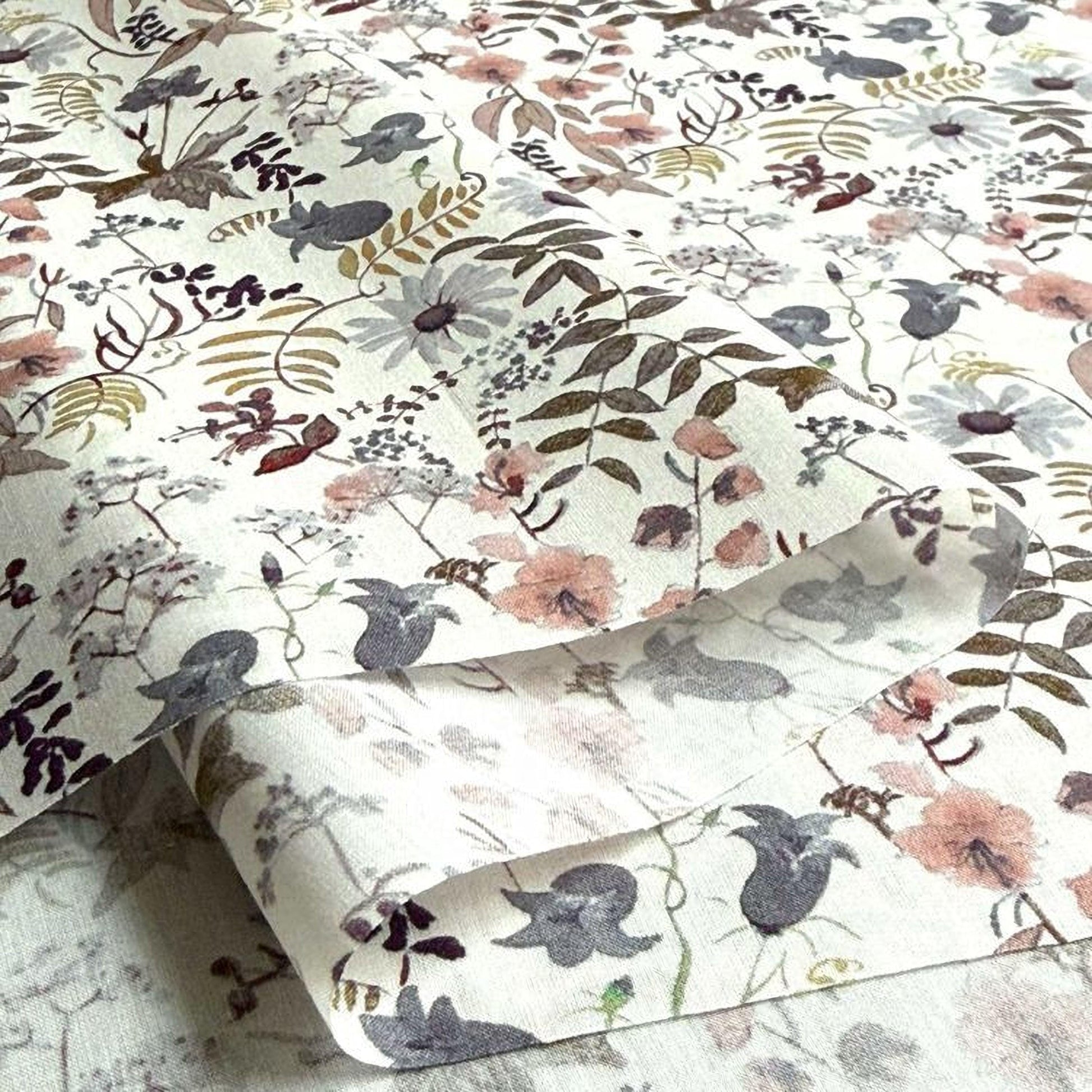 a close-up view of a fabric with a floral pattern, including various shades of pink, white, and brown flowers and leaves.