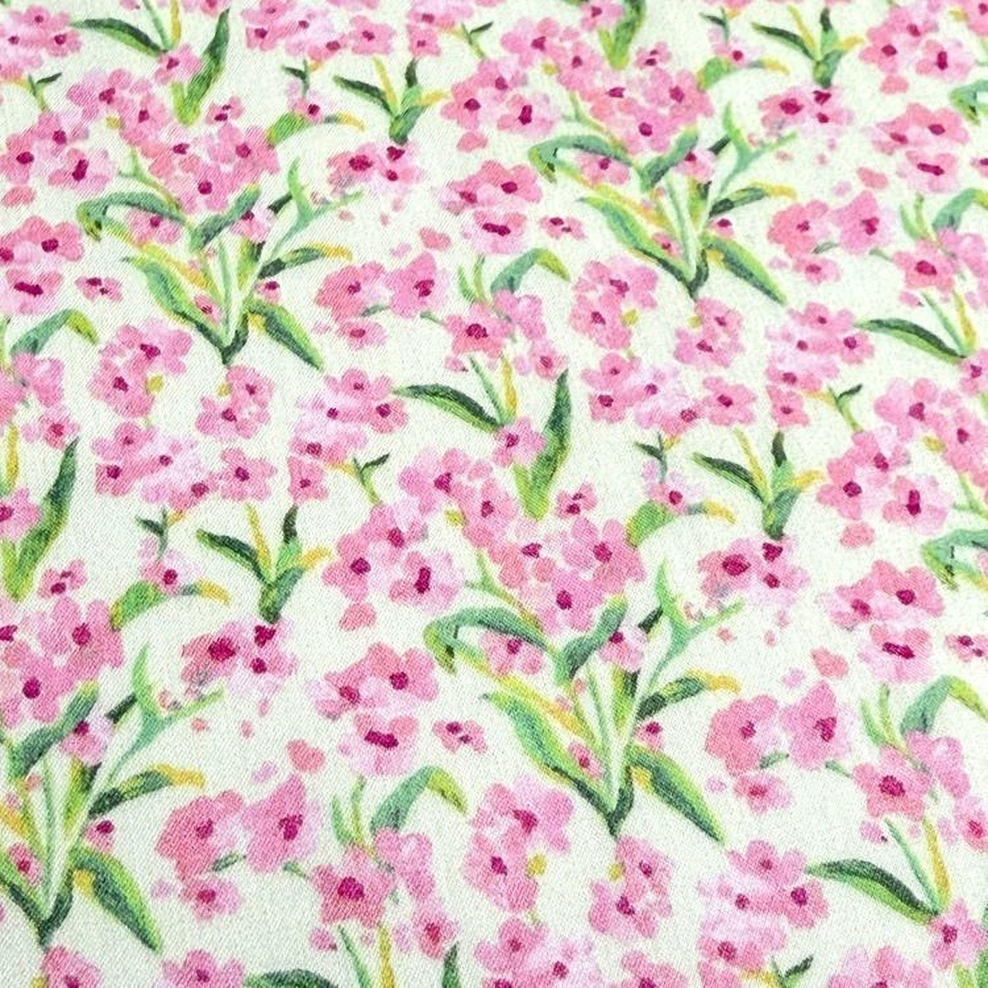 a close-up view of a fabric with a repeating pattern of pink flowers and green leaves.