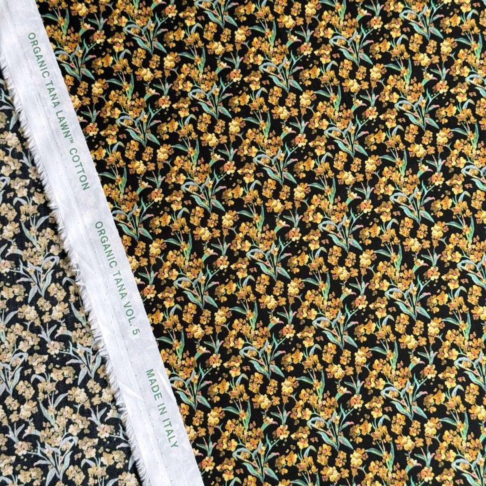 a close-up view of a fabric with a floral pattern, including yellow flowers and green leaves. The fabric appears to be made of organic cotton and is displayed alongside a white label that reads "Organic TANA LYNCH COTTON VOL. 5 MADE IN ITALY".