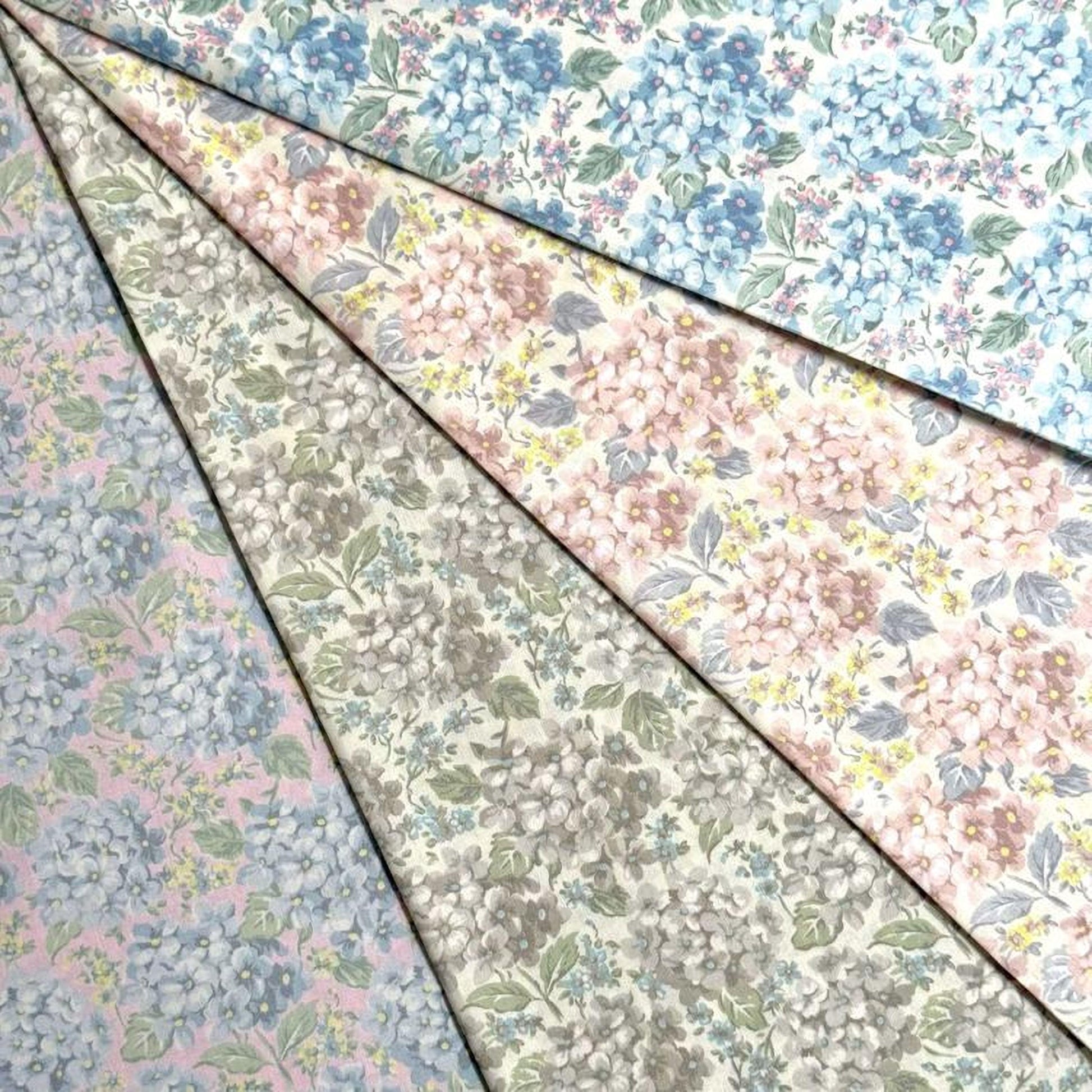 a collection of fabric swatches with various floral patterns, including blue, pink, and white flowers.
