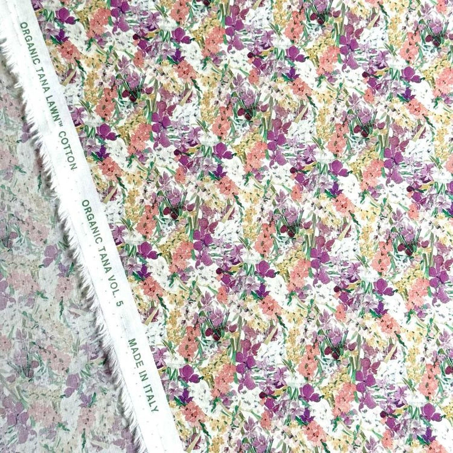 a fabric with a floral pattern, including various shades of pink, yellow, and green flowers. The fabric appears to be made of organic cotton and is displayed on a white background.