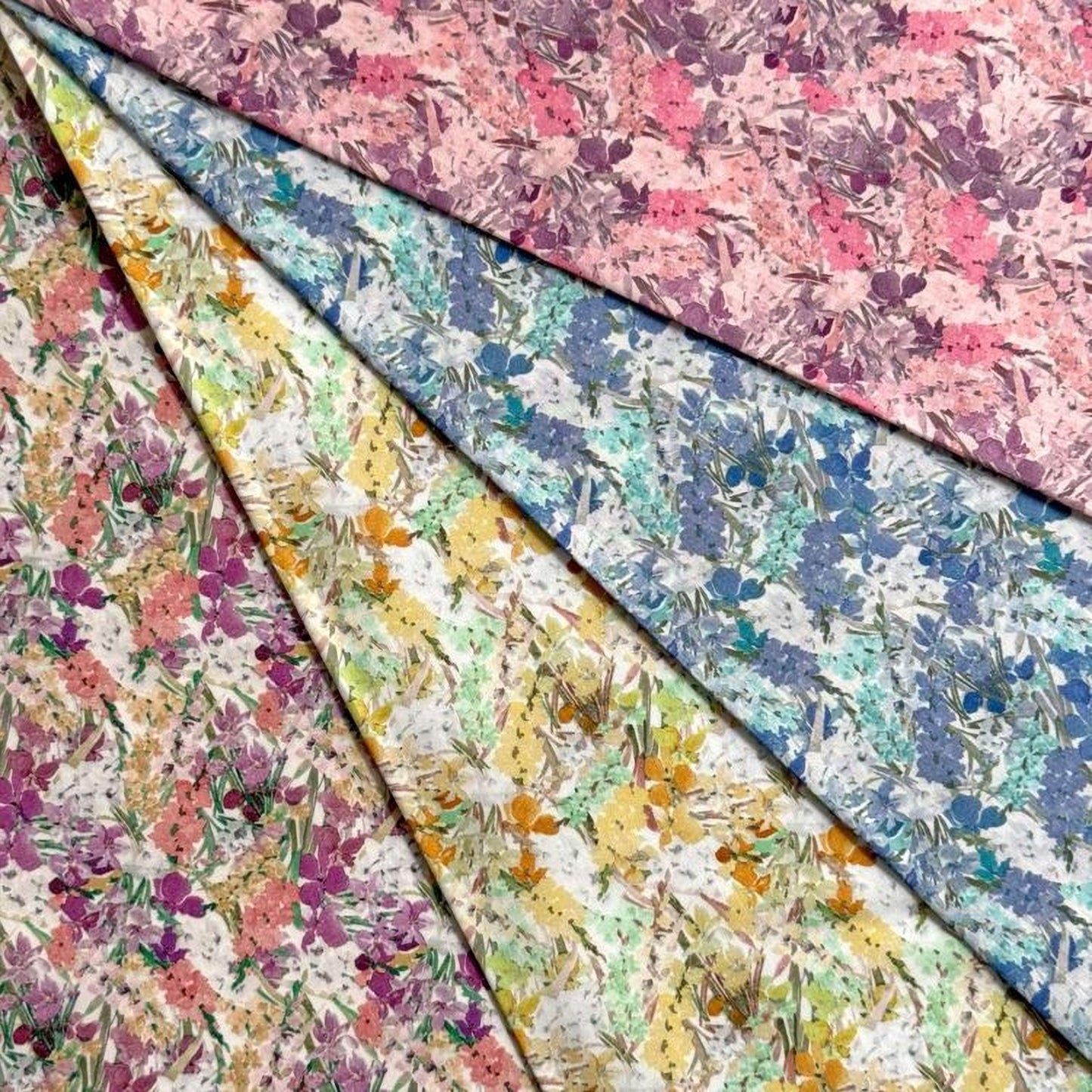 a collection of fabric swatches with various floral patterns, including pink, blue, yellow, and green designs.