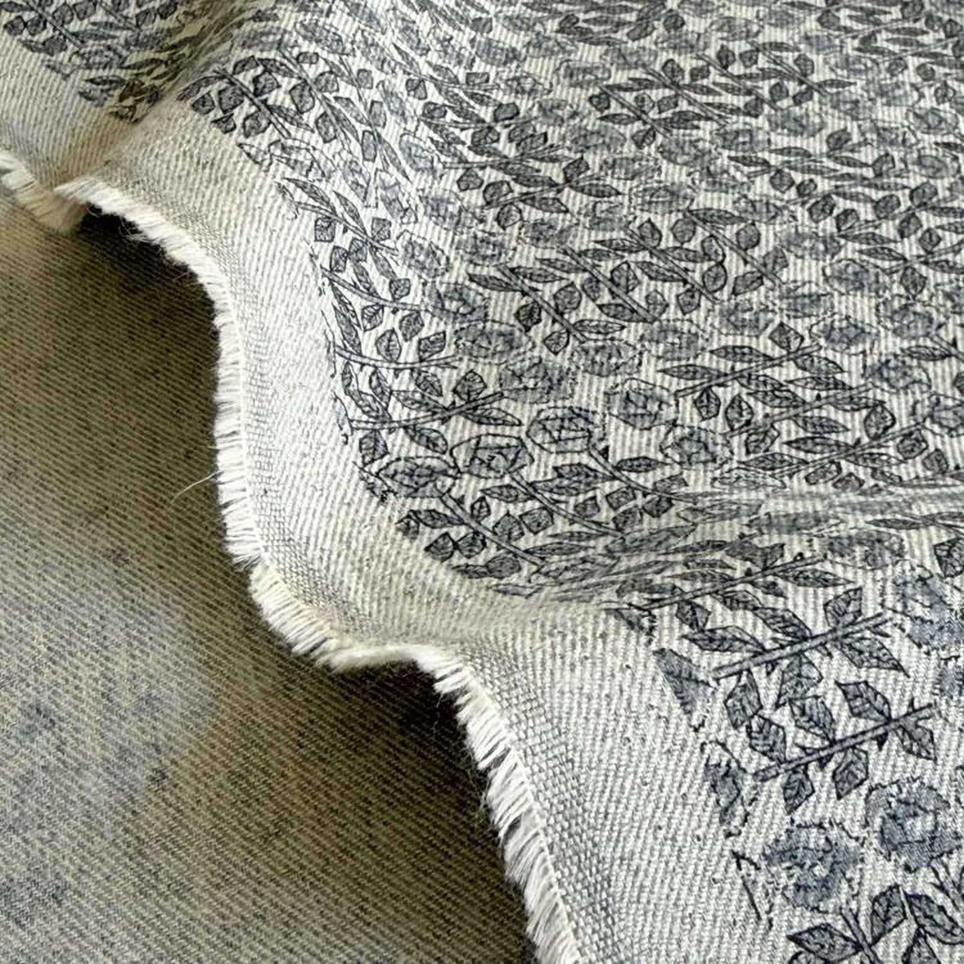 a close-up view of a fabric with a repeating pattern of leaves and flowers, creating a textured and visually interesting design.