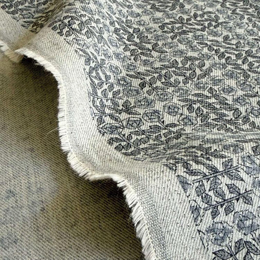 a close-up view of a fabric with a repeating pattern of leaves and flowers, creating a textured and visually interesting design.