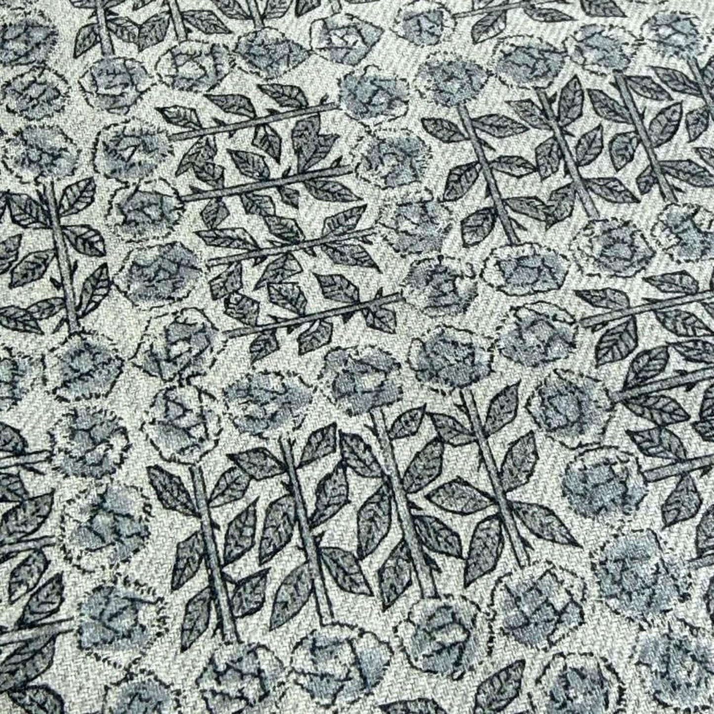a close-up view of a fabric with a repeating pattern of black and white flowers and leaves.