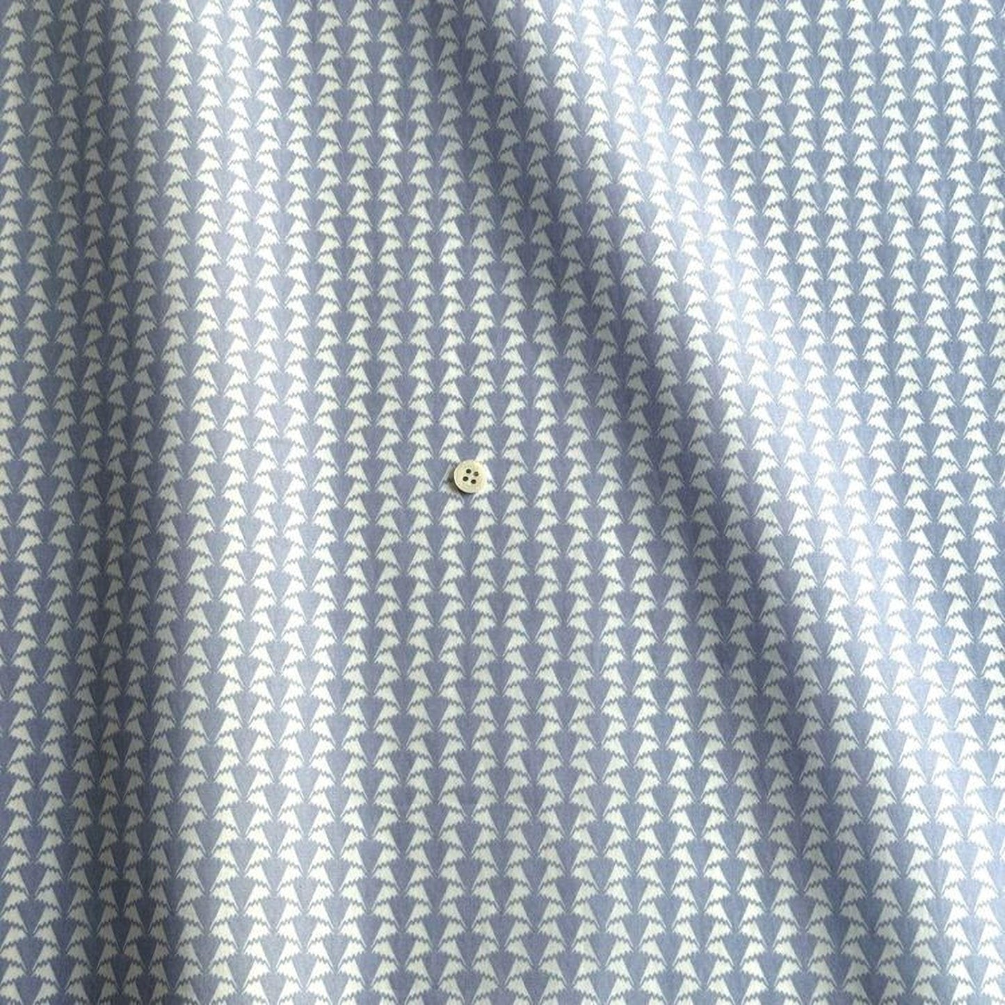 a close-up view of a fabric with a repeating pattern of small white triangles, creating a textured and visually interesting design.