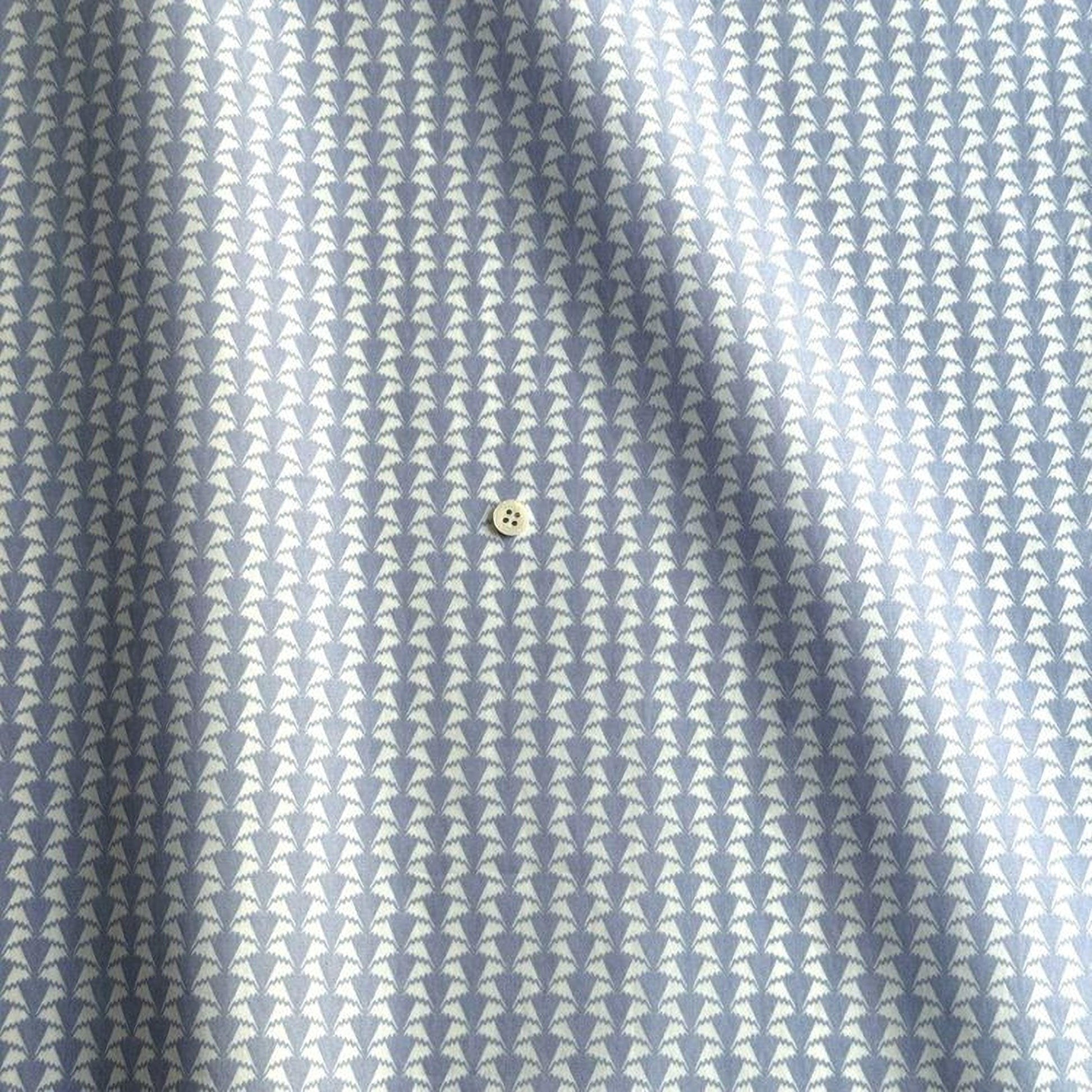 a close-up view of a fabric with a repeating pattern of small white triangles, creating a textured and visually interesting design.