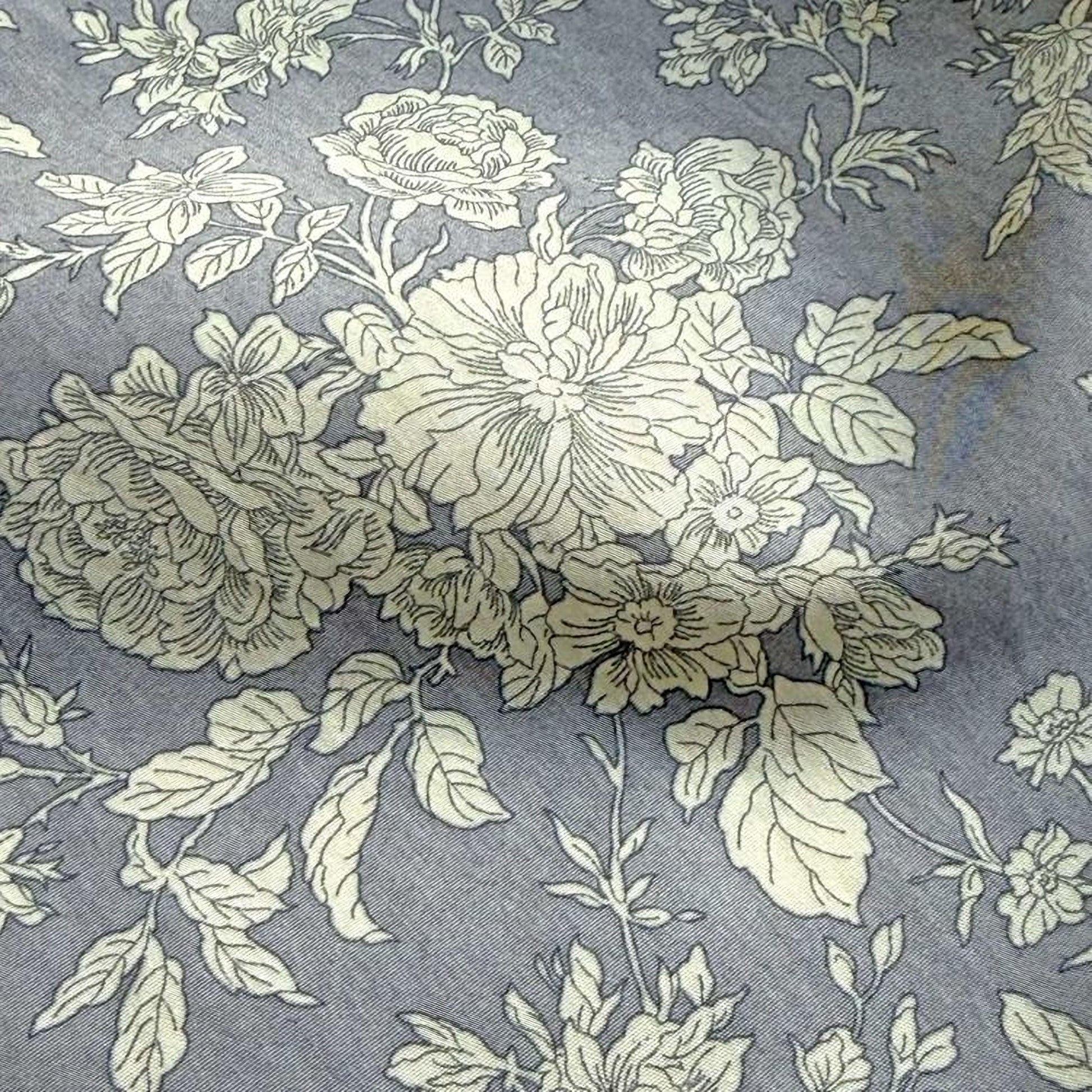 a close-up view of a fabric with a floral pattern. The fabric appears to be gray in color, and the pattern consists of various flowers and leaves, creating a visually appealing design.