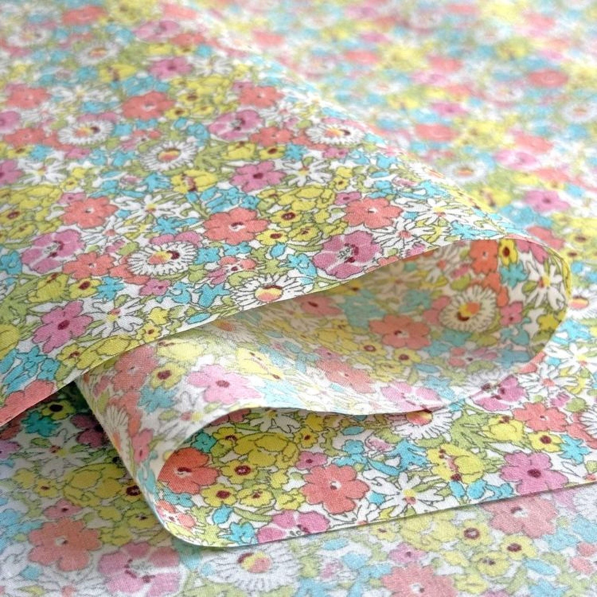a close-up view of a fabric with a vibrant floral pattern in shades of pink, yellow, and blue.