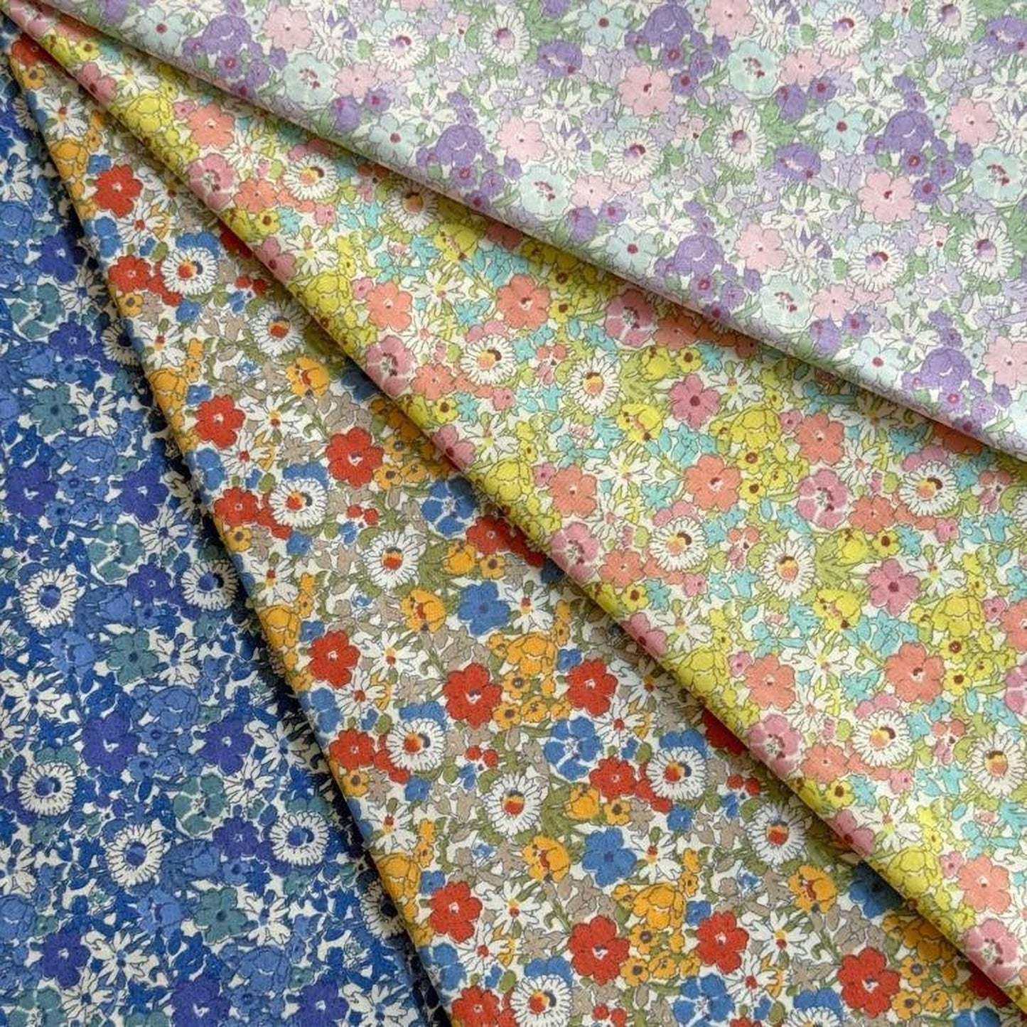 a collection of colorful fabric swatches, each with a unique floral pattern. The swatches are arranged in a way that showcases the variety of designs and colors available.