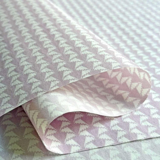 a close-up view of a piece of paper with a repeating pattern of white triangles on a light purple background.