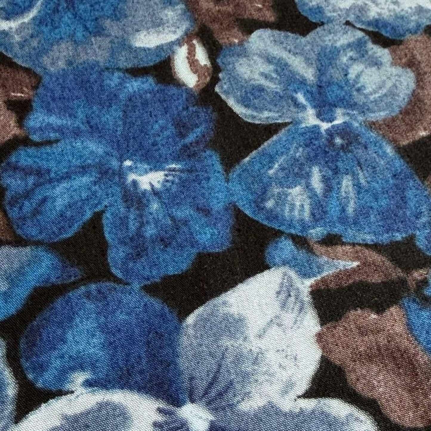 a close-up view of a fabric with a floral pattern in shades of blue and brown.