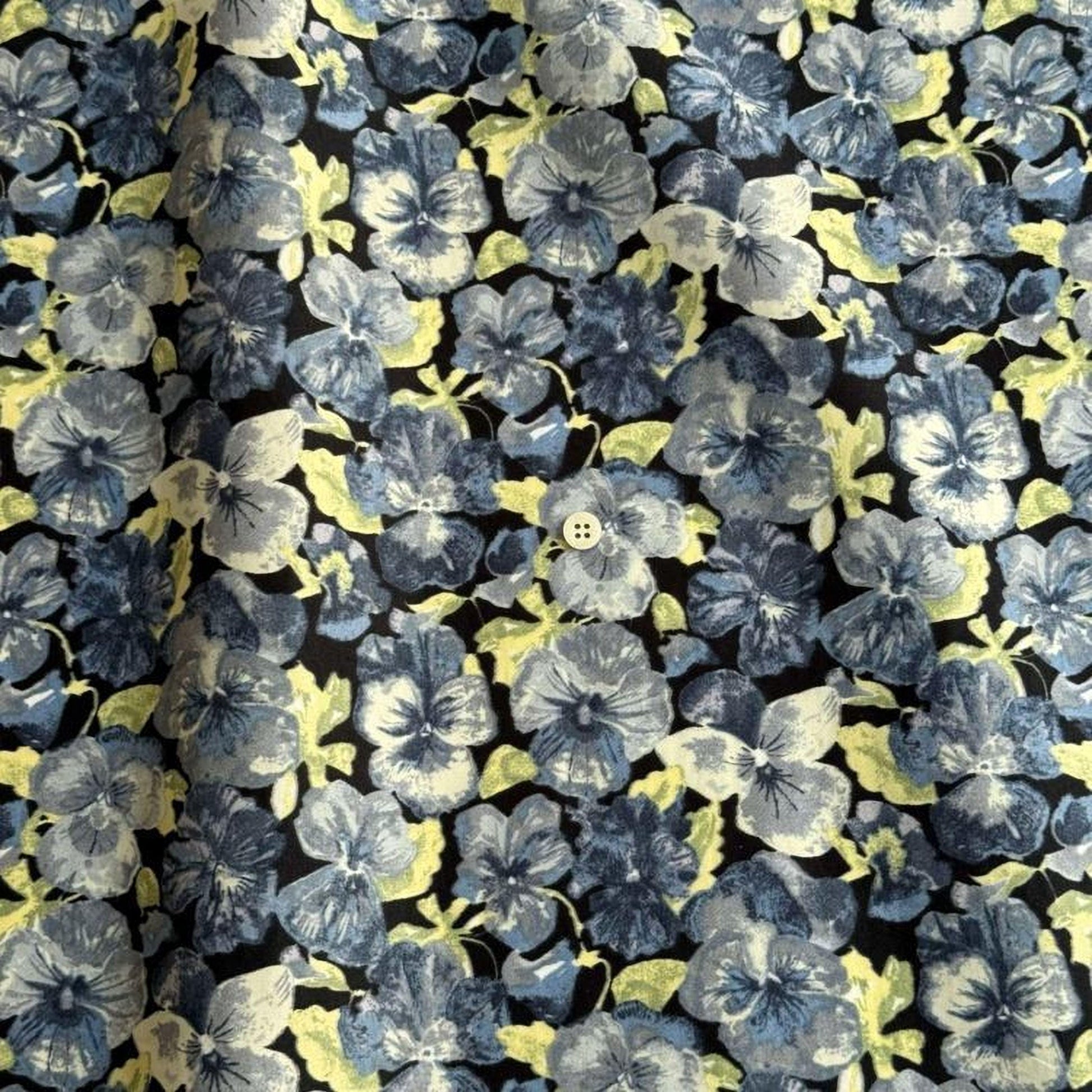 a close-up view of a fabric with a repeating pattern of blue and yellow flowers. The flowers are arranged in a way that fills the entire frame, creating a visually striking and vibrant design.