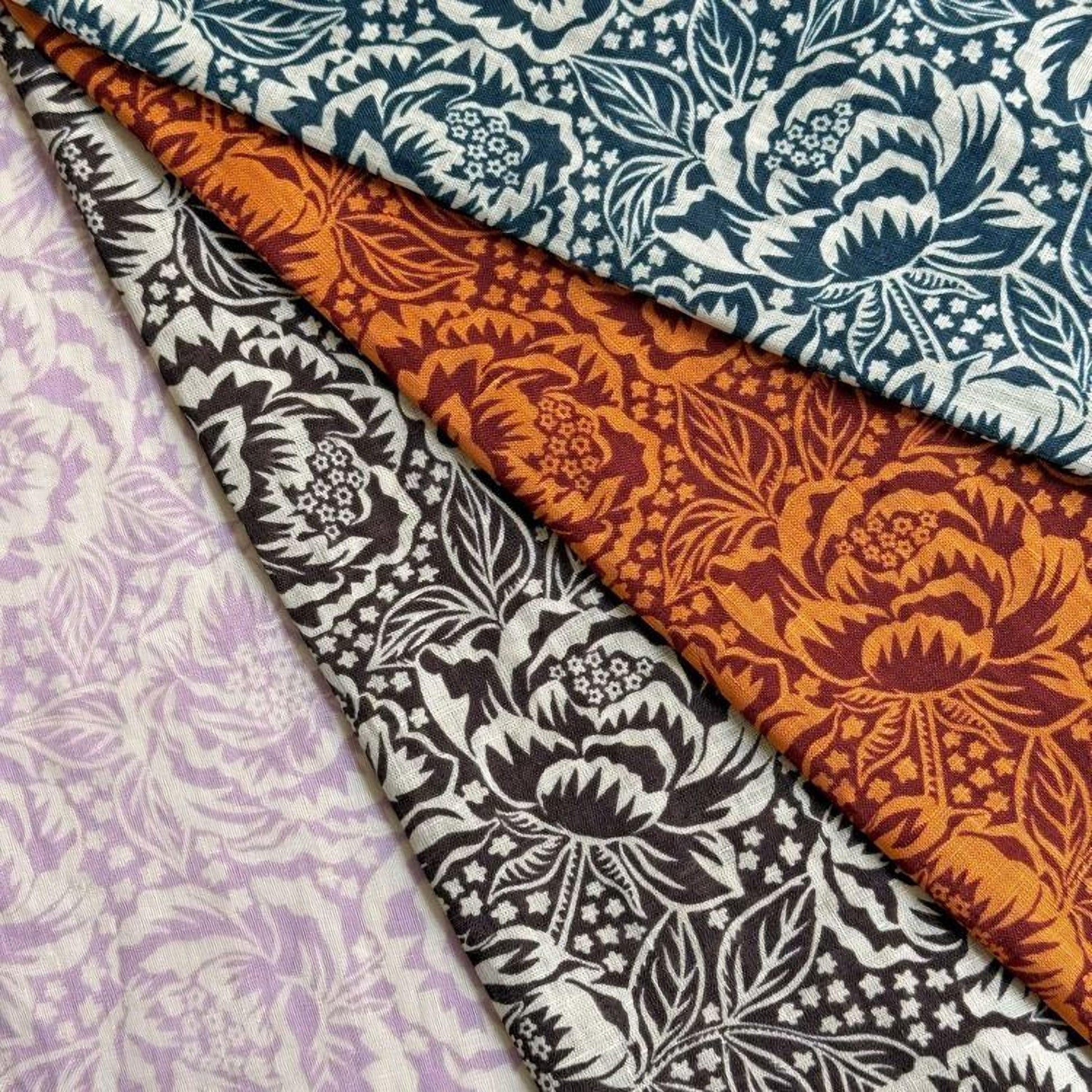 four fabric swatches with different floral patterns, including white, black, orange, and purple designs.
