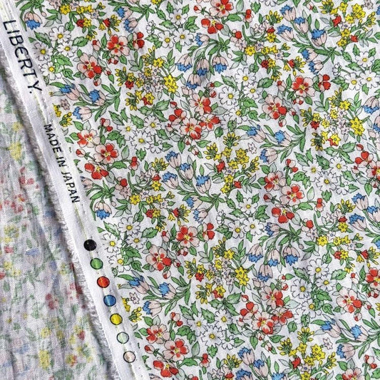 a close-up view of a fabric with a vibrant floral pattern, including various colors and shapes of flowers and leaves.