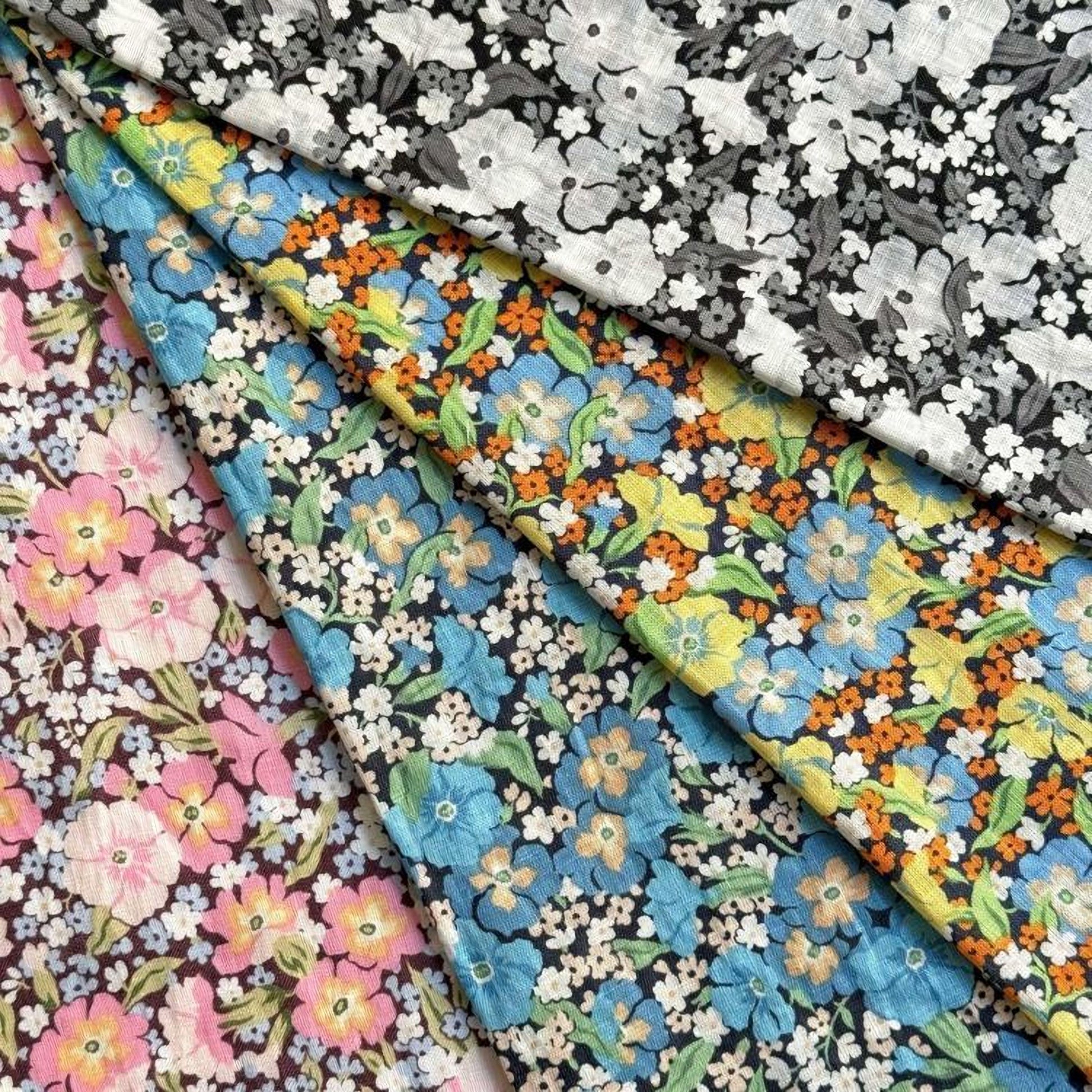 a collection of fabric swatches with various floral patterns, including white, black, and colorful floral designs.