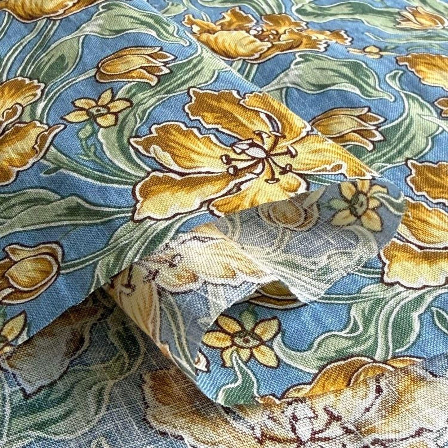 a close-up view of a fabric with a floral pattern in shades of blue, green, and yellow.
