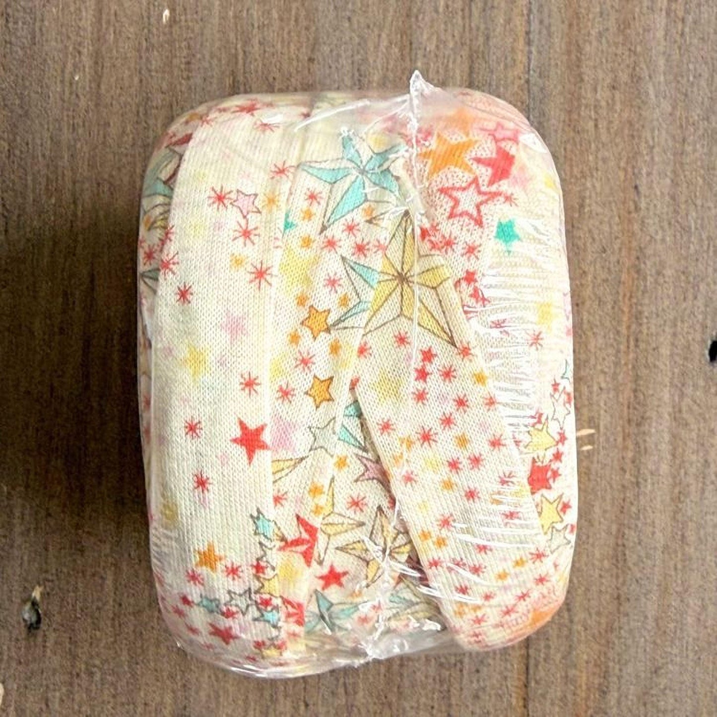 A wrapped object with a star-patterned fabric covering it, placed on a wooden surface.
