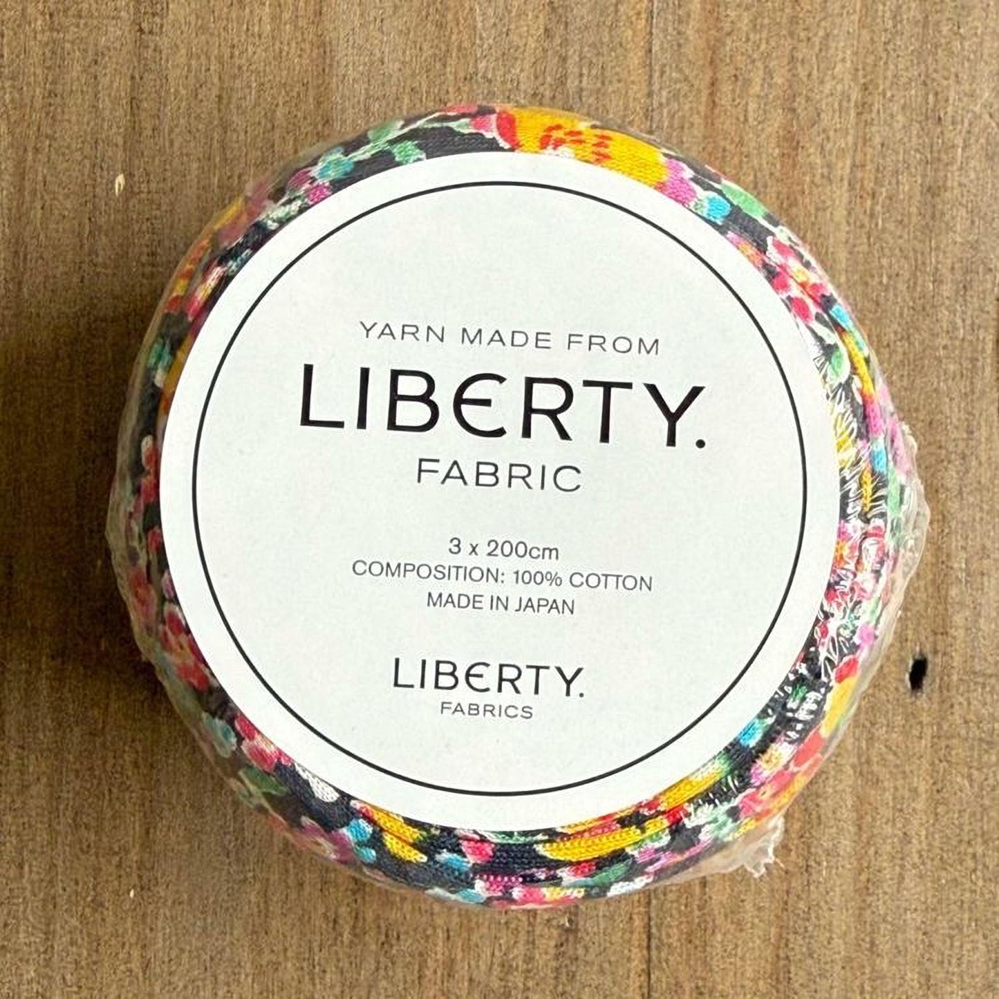 A white label with black text on a circular background, which appears to be a product label for a fabric.