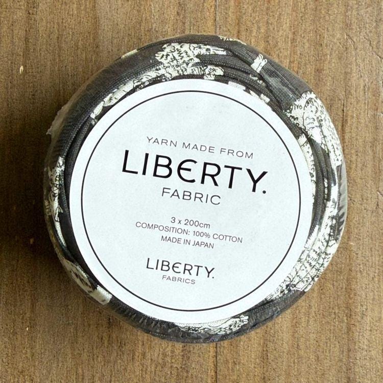 A white label with black text on a black and white fabric container.