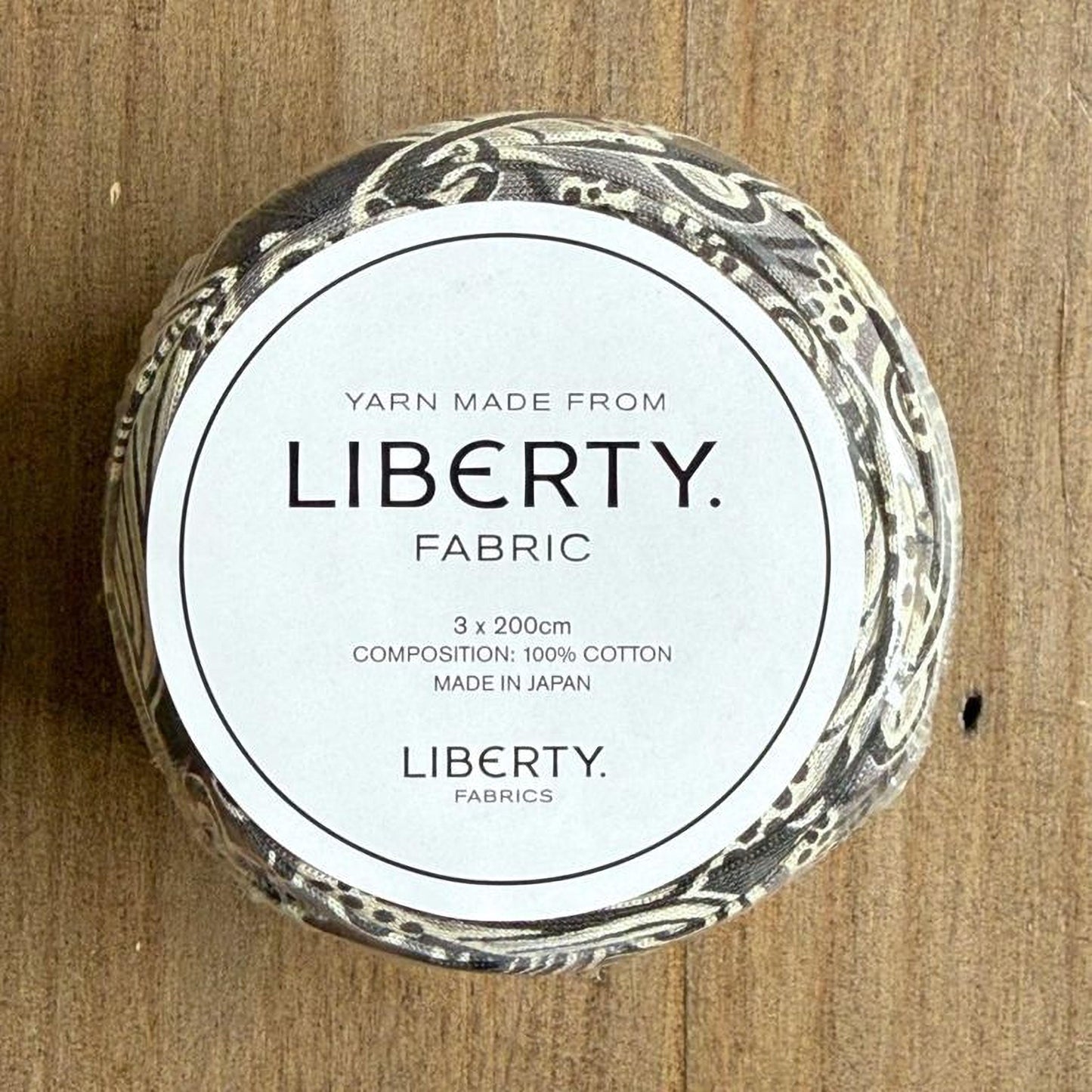 A circular object with text on it, placed on a wooden surface.