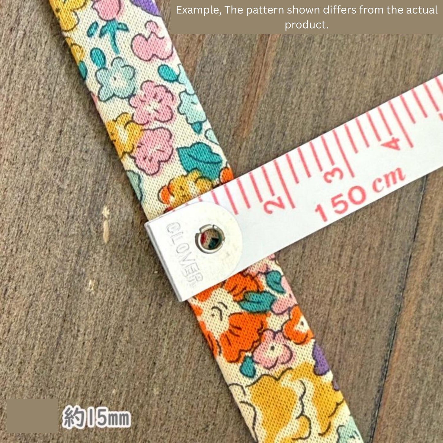 A colorful fabric with a floral pattern is being measured with a ruler, which is placed on a wooden surface.