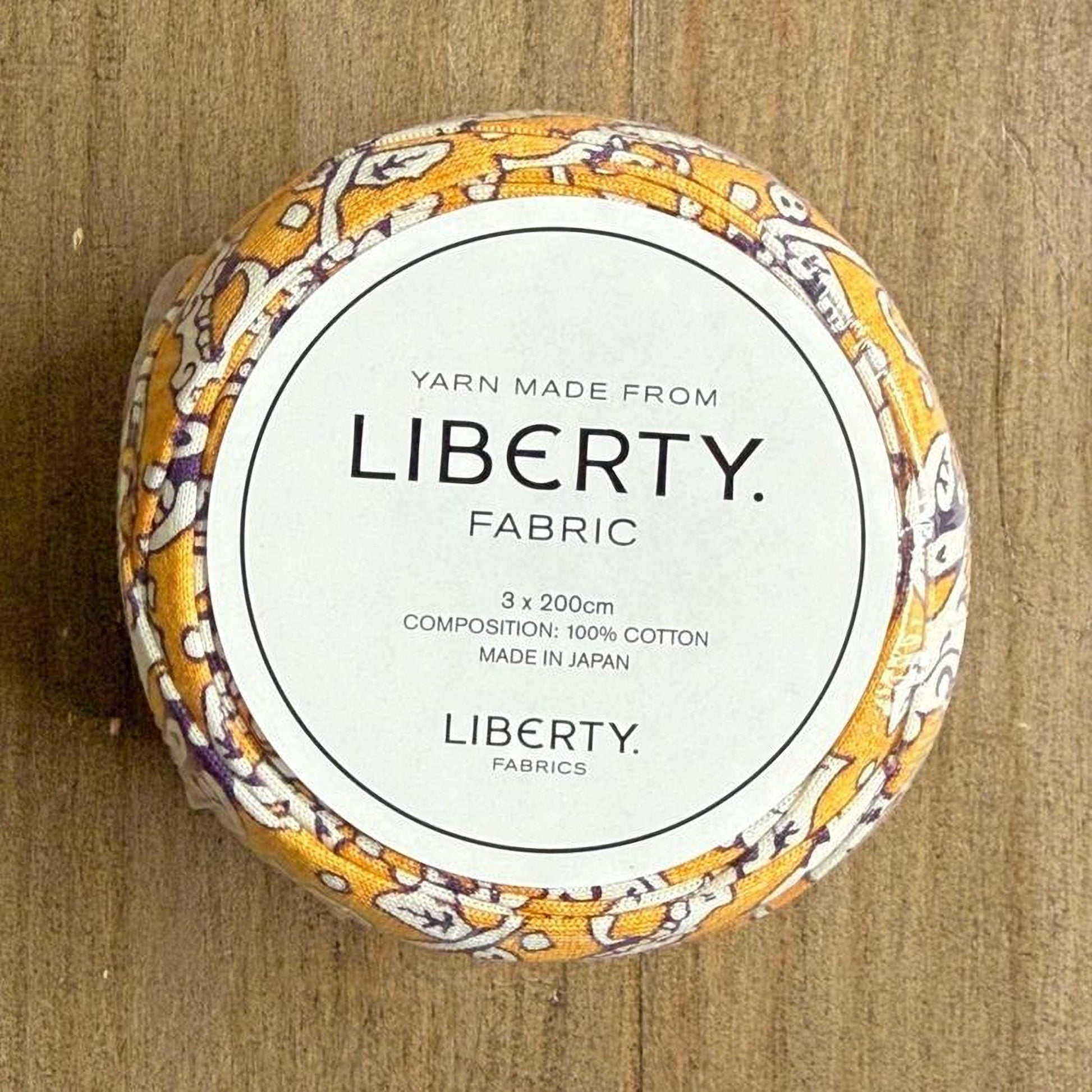 A circular object with a label that reads "YARN MADE FROM LIBERTY FABRIC".