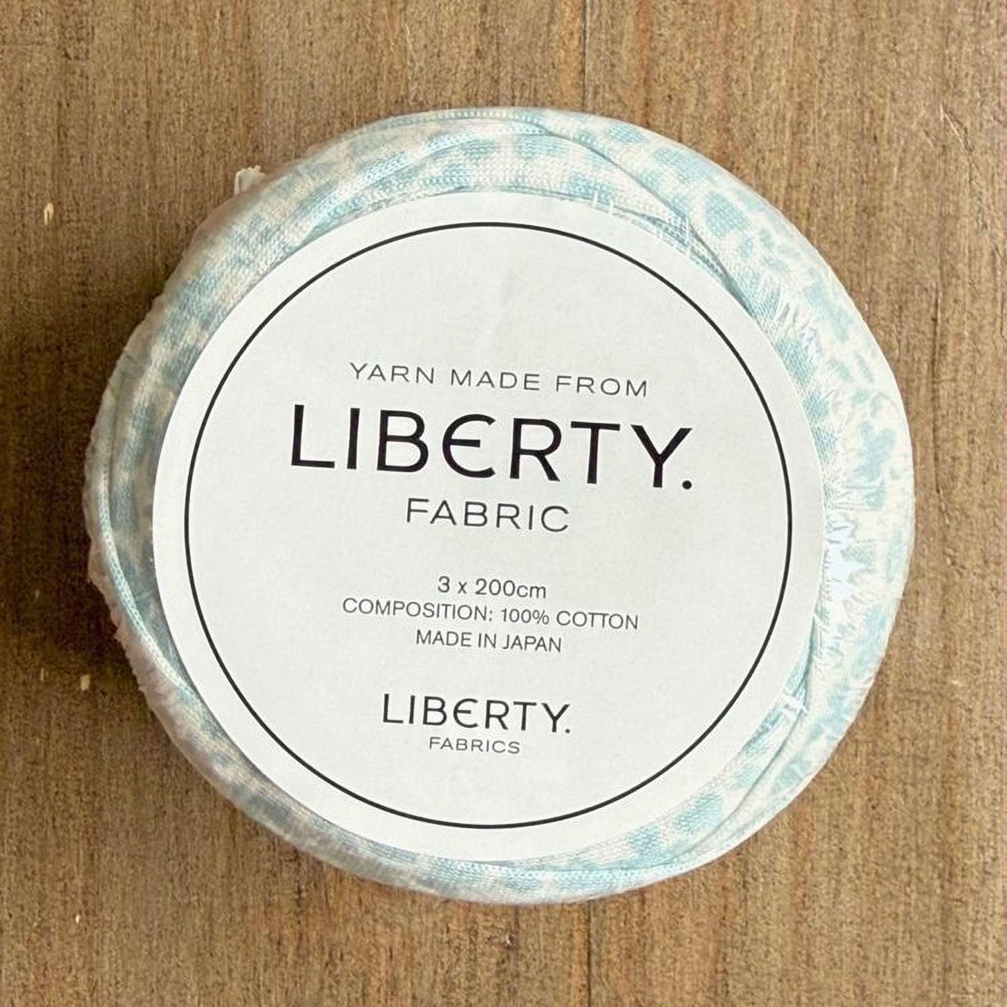 A white label with black text on a circular background, placed on a wooden surface.