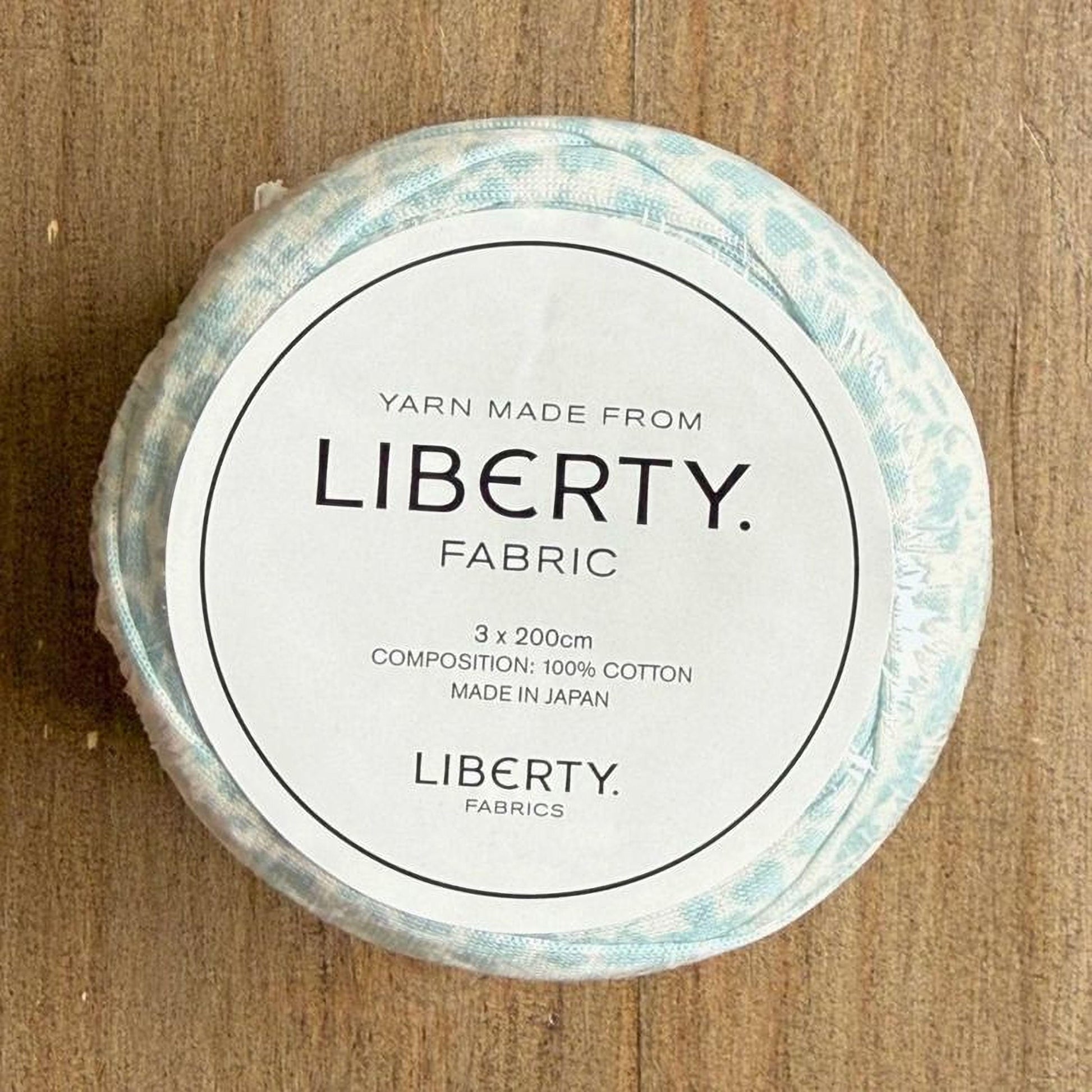 A white label with black text on a circular background, placed on a wooden surface.