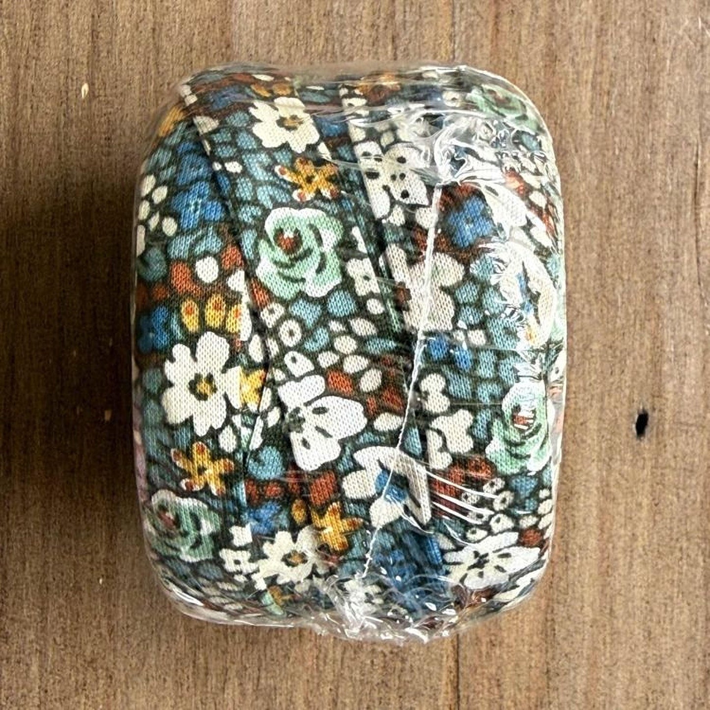 A clear plastic bag containing a colorful fabric with a floral pattern.