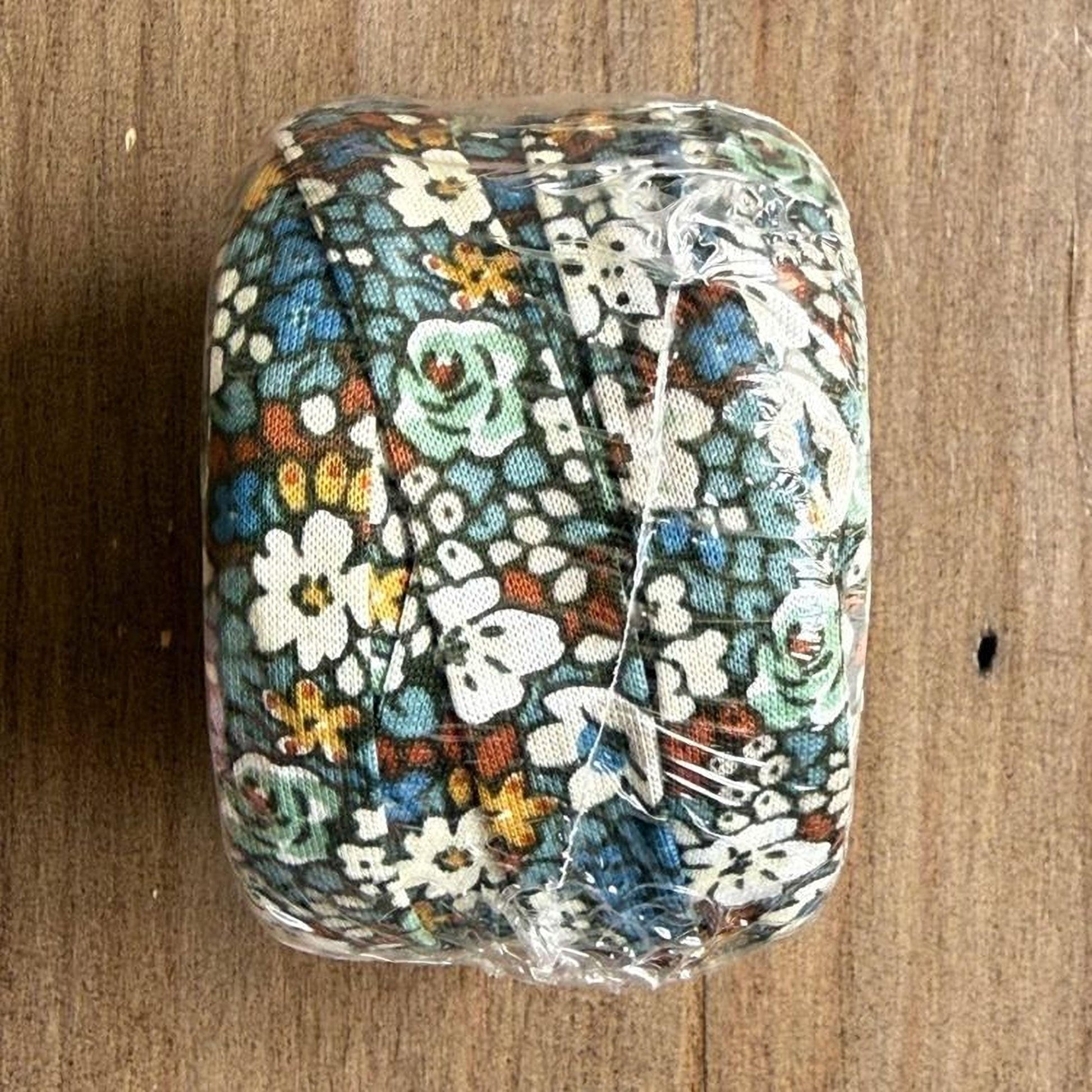 A clear plastic bag containing a colorful fabric with a floral pattern.