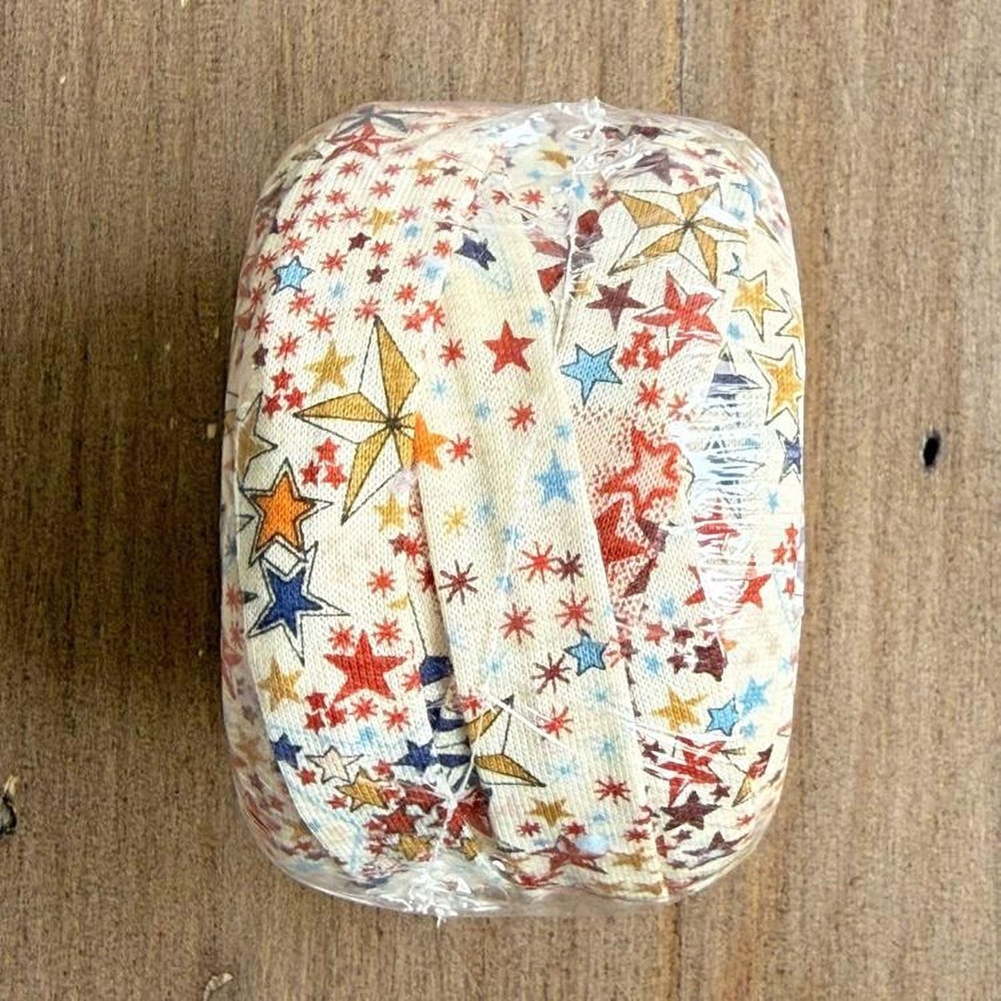 A clear plastic bag containing a fabric with a colorful star pattern design.