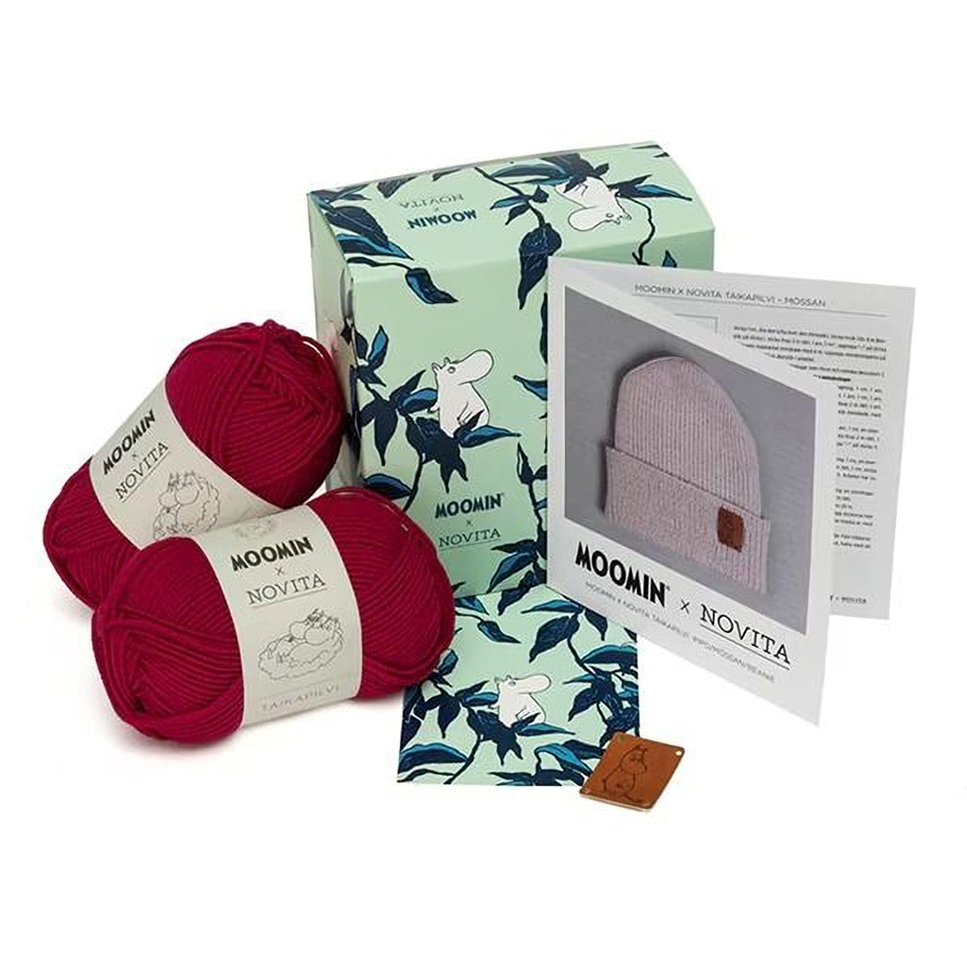 a collection of knitting supplies, including yarn, a box, and a booklet, all featuring the Moomin brand.