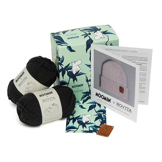 various knitting supplies, including yarn, a box, and a booklet, all related to knitting.