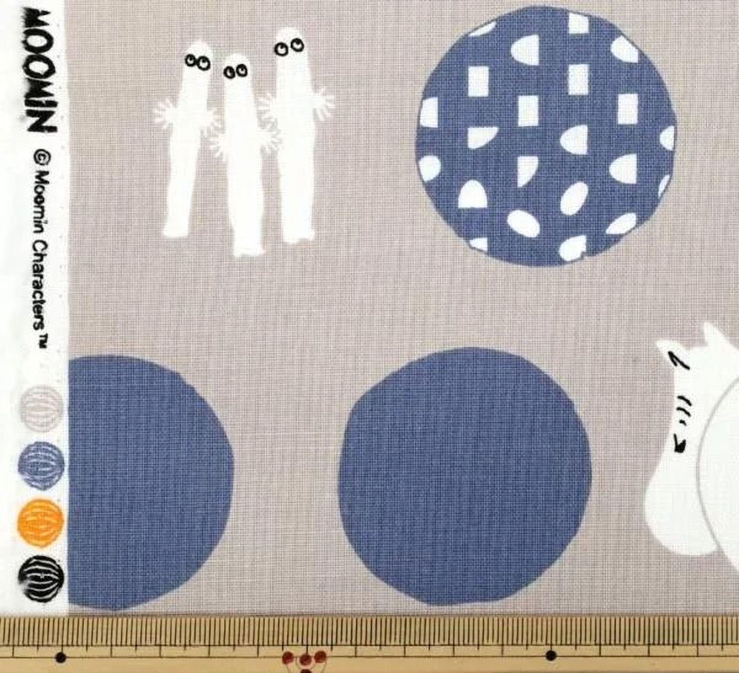 The image is a fabric with various patterns and designs, including circles, dots, and silhouettes of people.