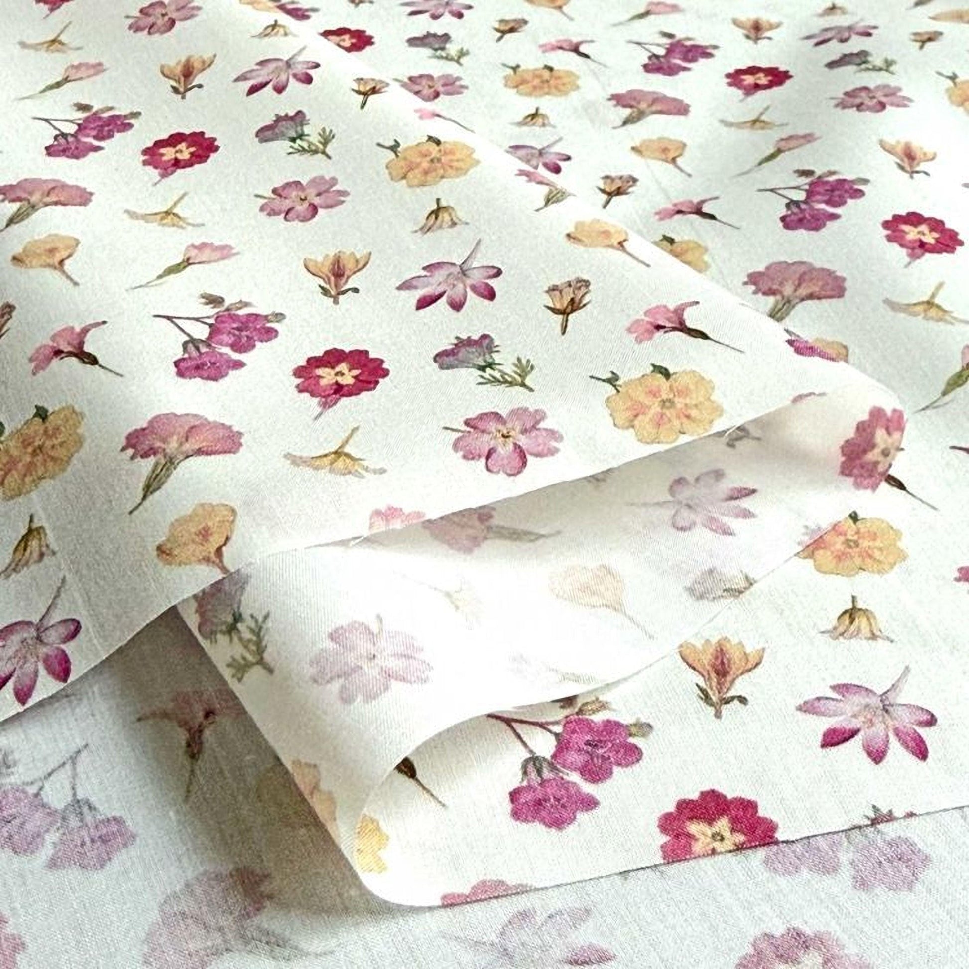 a close-up view of a fabric with a repeating floral pattern of various colors, including pink, yellow, and purple flowers.