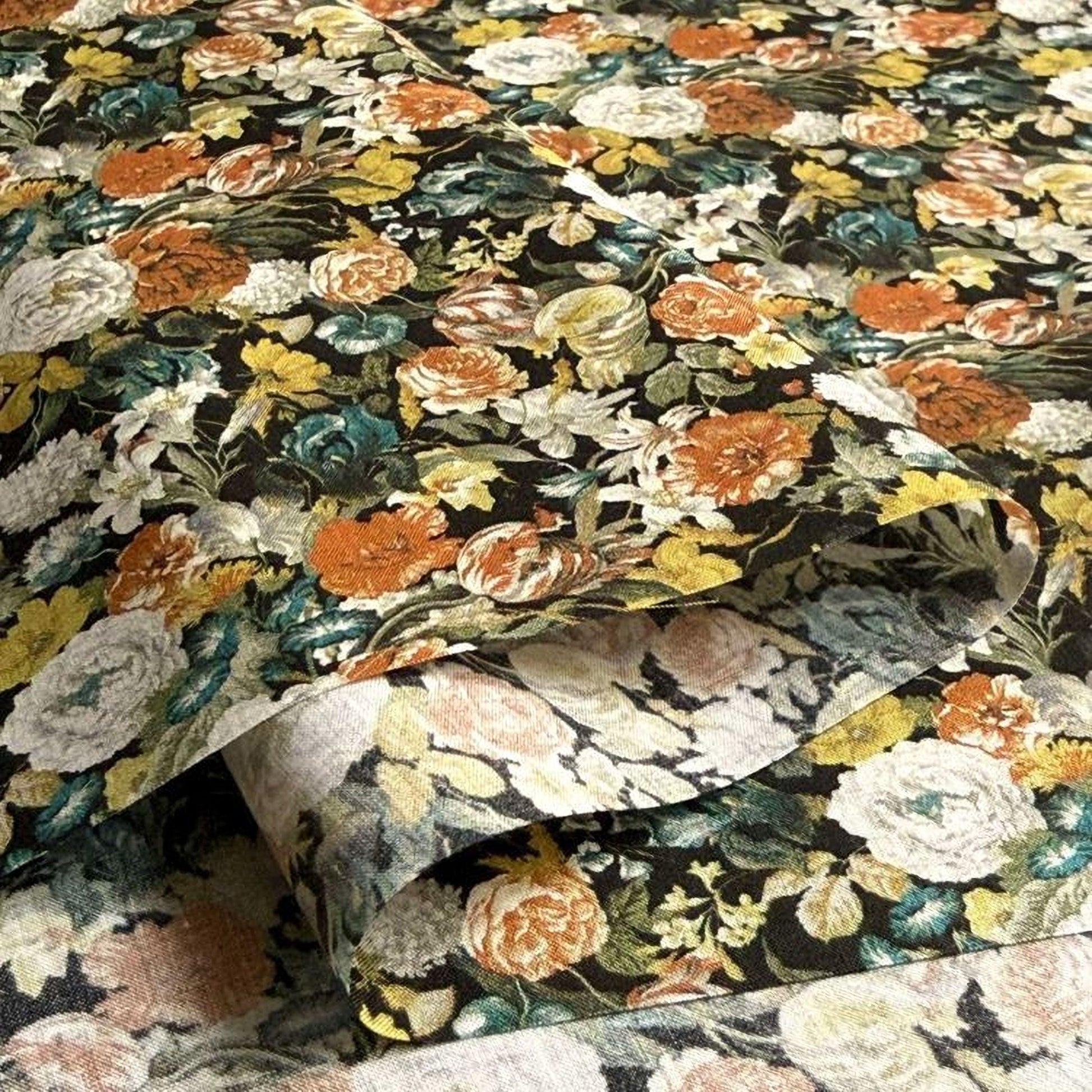 a close-up view of a fabric with a vibrant floral pattern in shades of orange, yellow, and white. The pattern is composed of various flowers and leaves, creating a visually striking and colorful design.