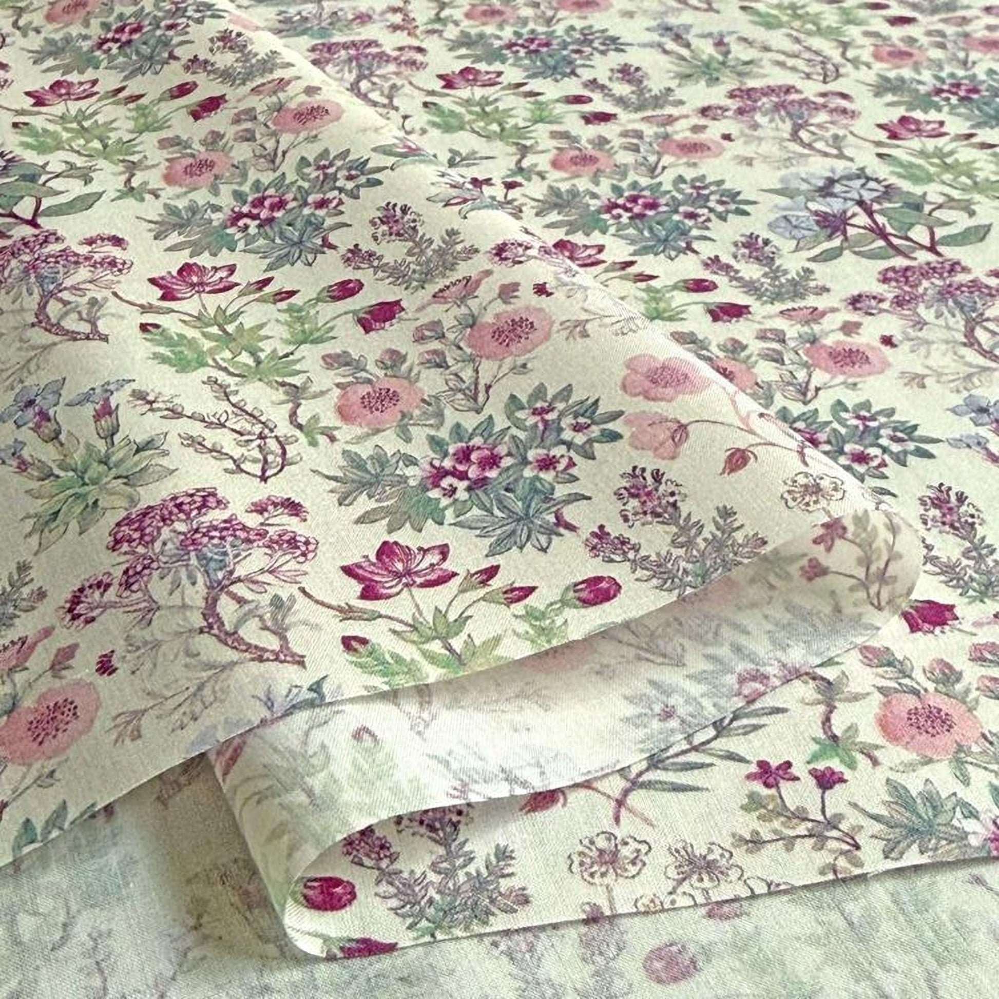 a close-up view of a fabric with a floral pattern, including various types of flowers and leaves in shades of pink, green, and purple.