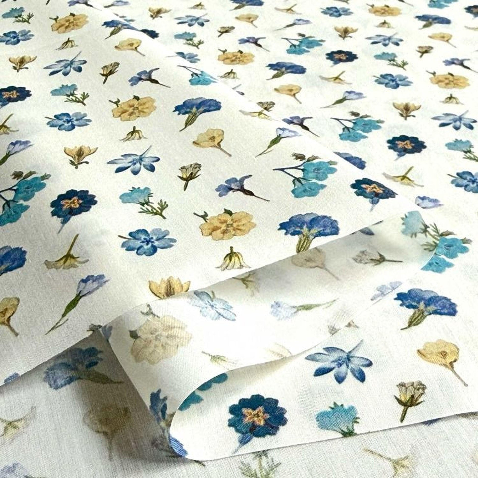 a close-up view of a fabric with a repeating floral pattern in shades of blue and yellow. The pattern consists of various flowers and leaves, creating a visually appealing and intricate design.