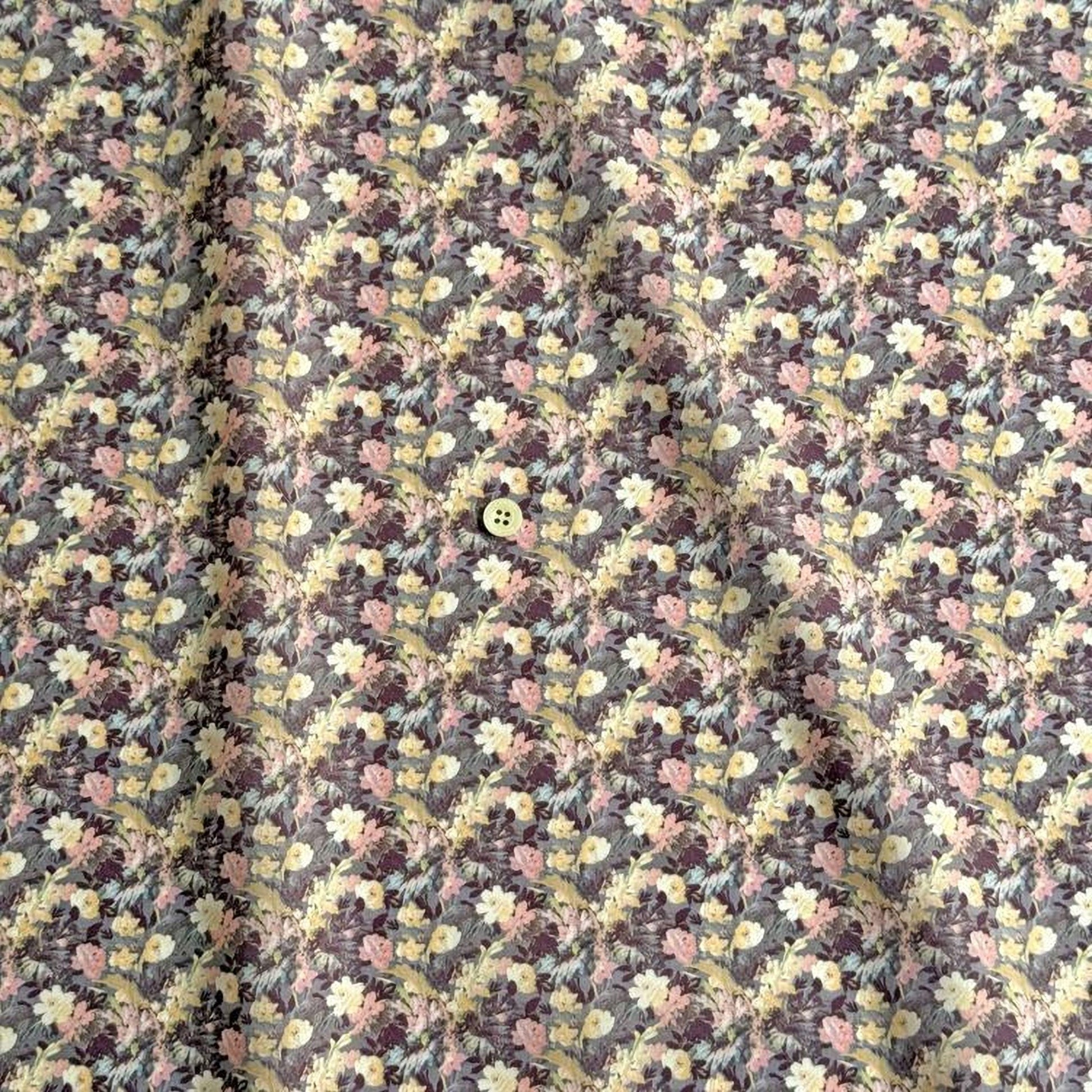 a close-up view of a fabric with a floral pattern, featuring a small button in the center.
