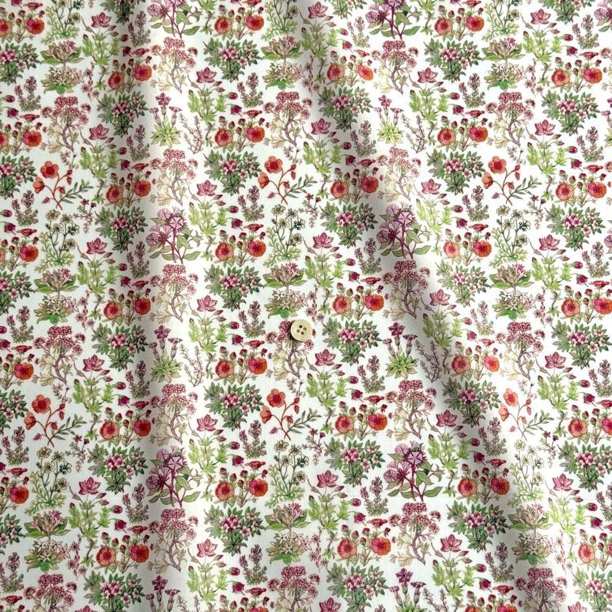 a fabric with a repeating floral pattern in shades of green, red, and pink. The pattern consists of various flowers and leaves, creating a visually appealing and intricate design.