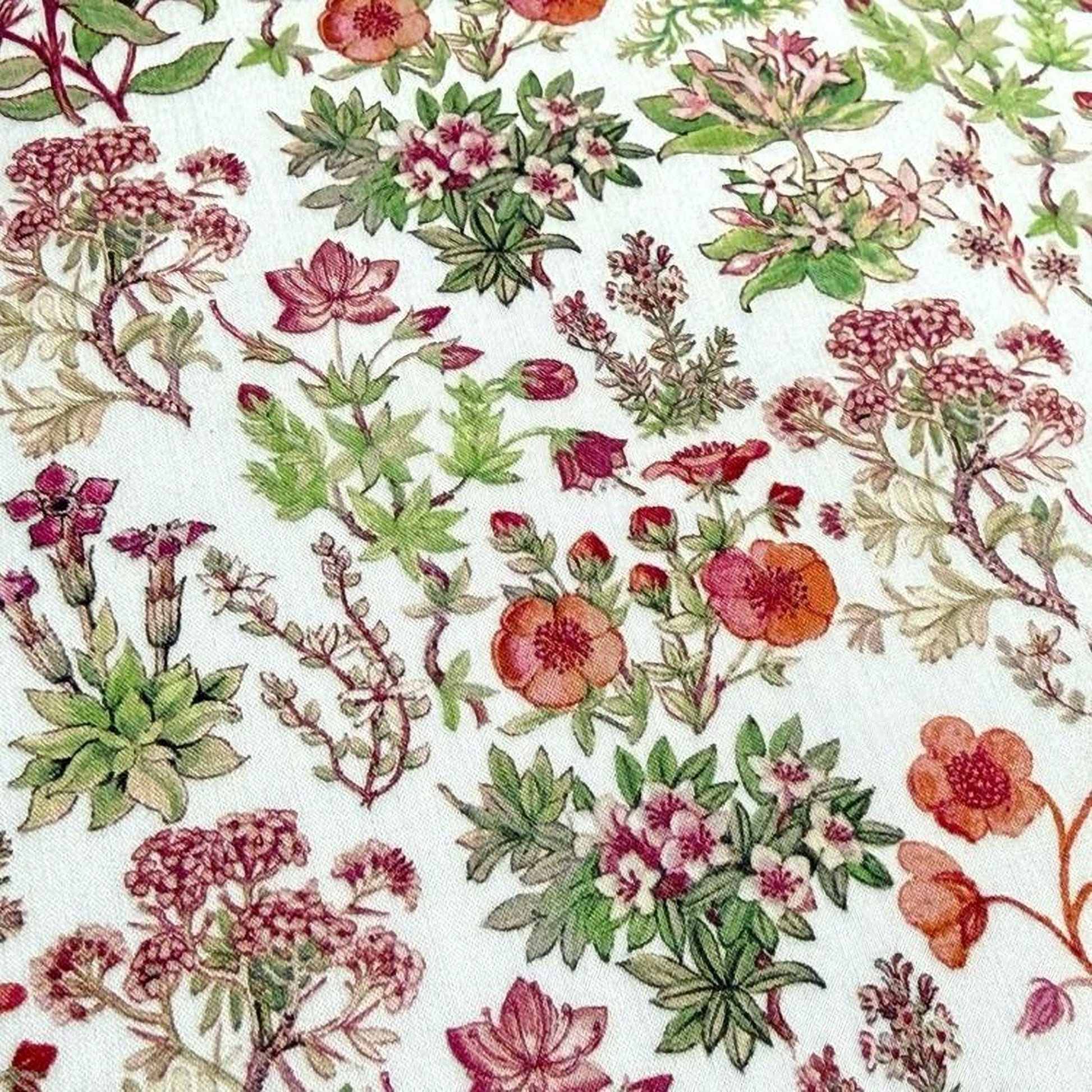 The image is a close-up of a fabric with a floral pattern, featuring various types of flowers and plants in shades of pink, green, and red.