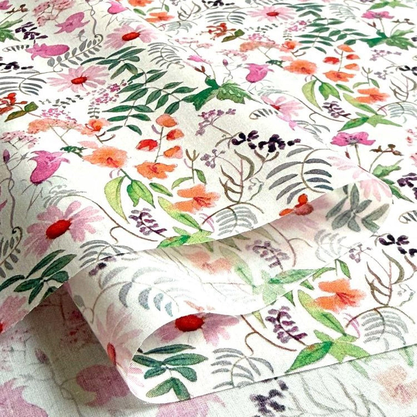 a close-up view of a fabric with a floral pattern, including various types of flowers and leaves in shades of pink, green, and purple.