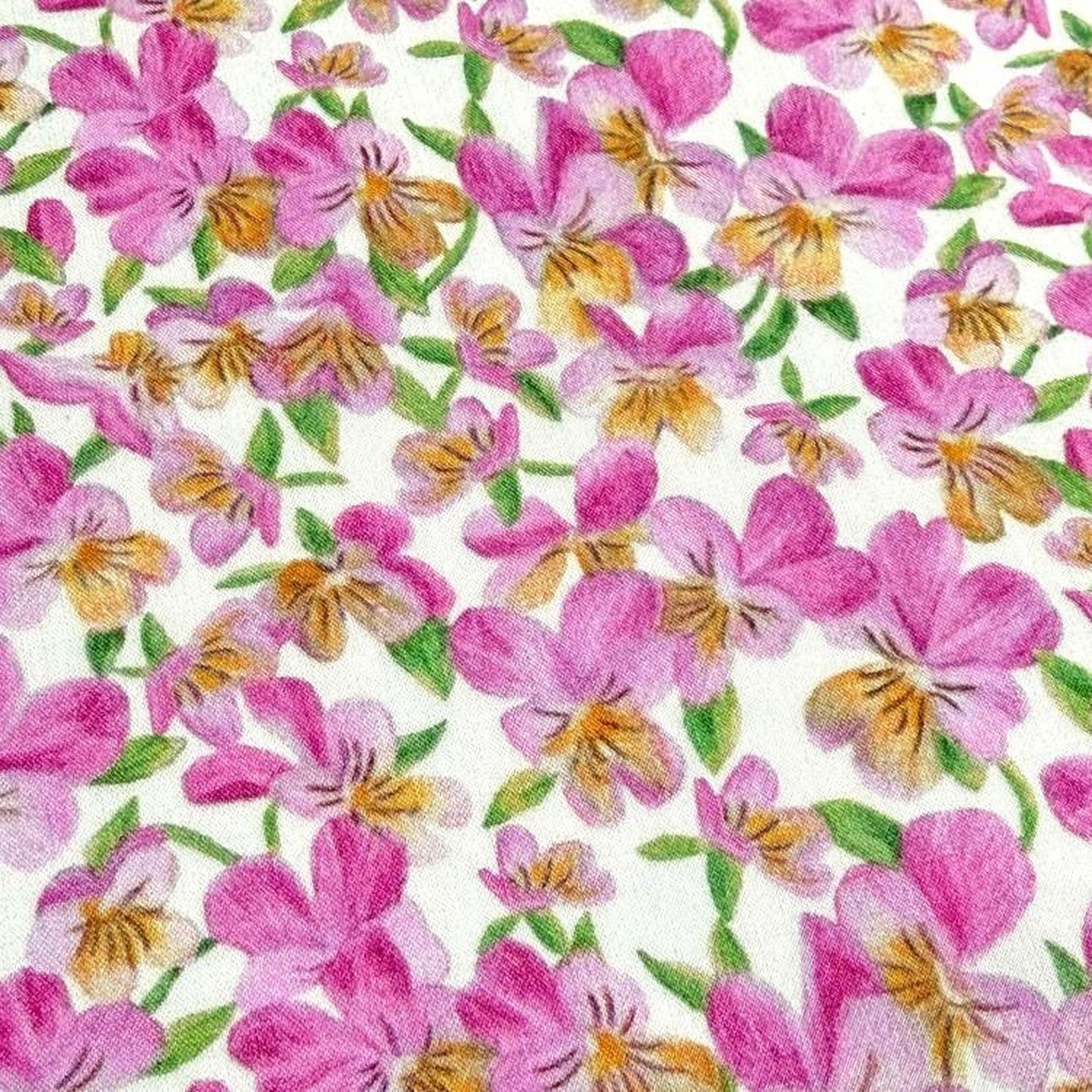 The image is a close-up of a fabric with a repeating pattern of pink and yellow flowers.