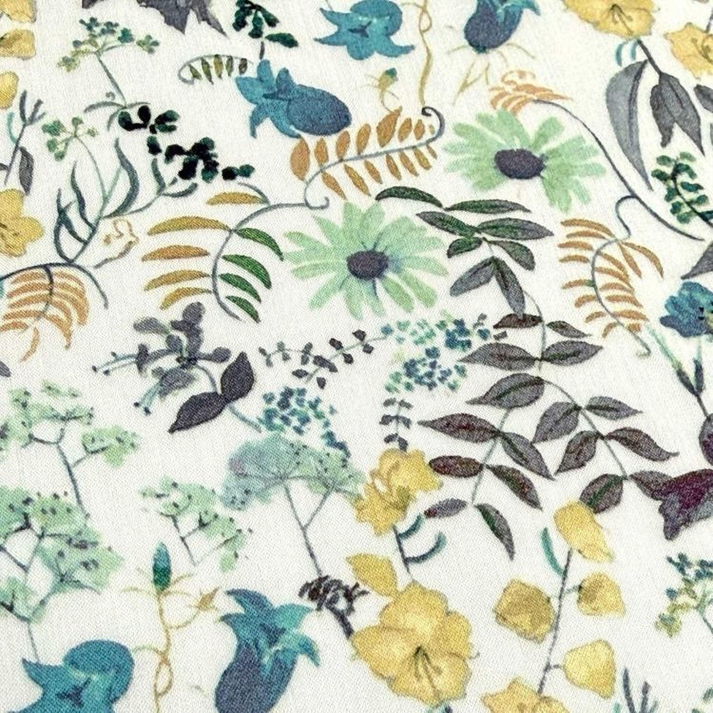 The image is a close-up of a fabric with a floral pattern, featuring various shades of green, yellow, and brown flowers and leaves.