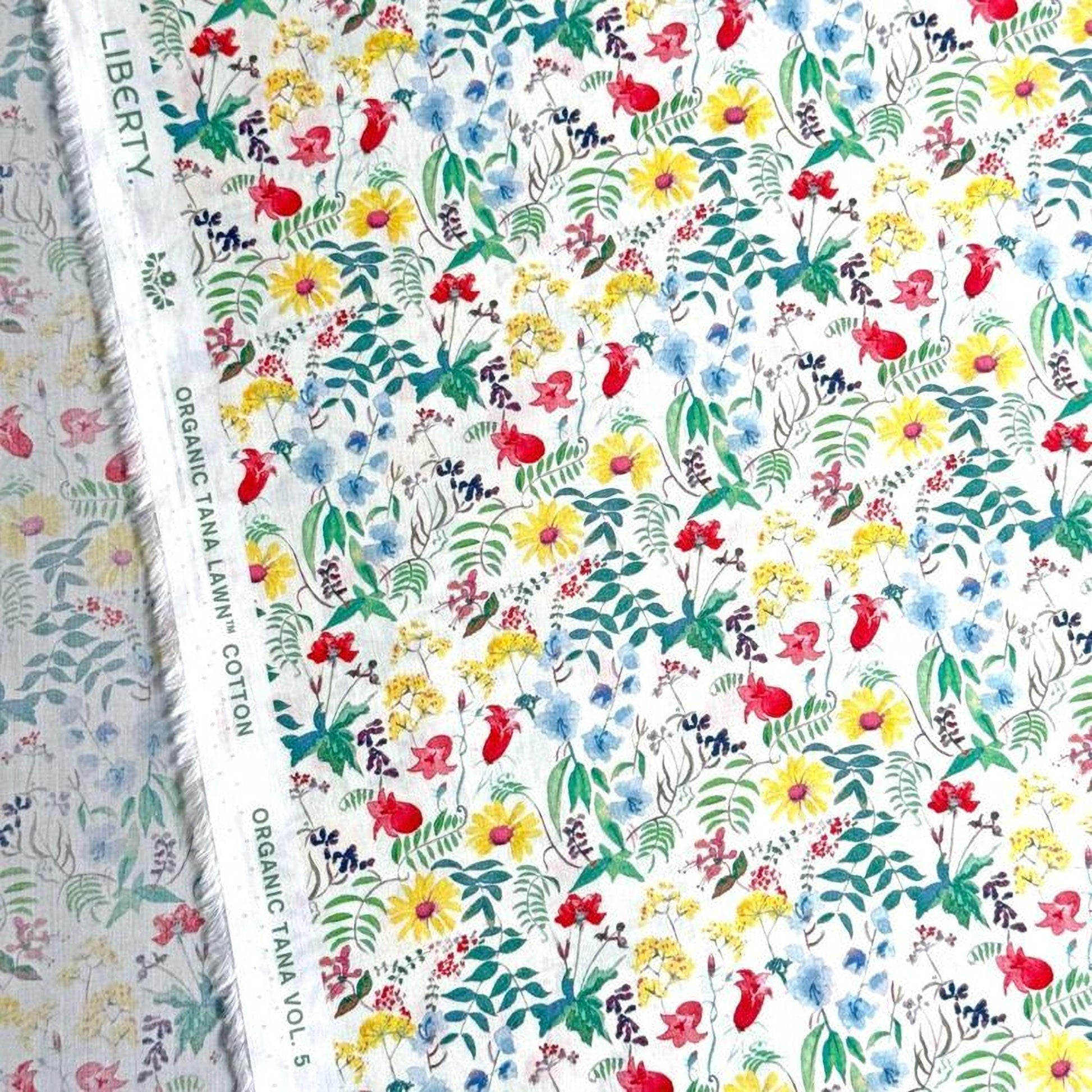 a vibrant and colorful floral print, with a variety of flowers and leaves in shades of red, yellow, green, and blue. The print appears to be a fabric or textile, with a label indicating it is "Liberty" and "Organic Tanna Cotton Vol. 5".