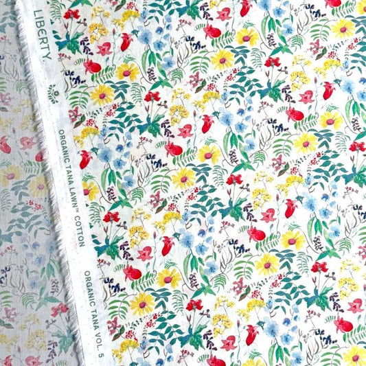 a vibrant and colorful floral print, with a variety of flowers and leaves in shades of red, yellow, green, and blue. The print appears to be a fabric or textile, with a label indicating it is "Liberty" and "Organic Tanna Cotton Vol. 5".