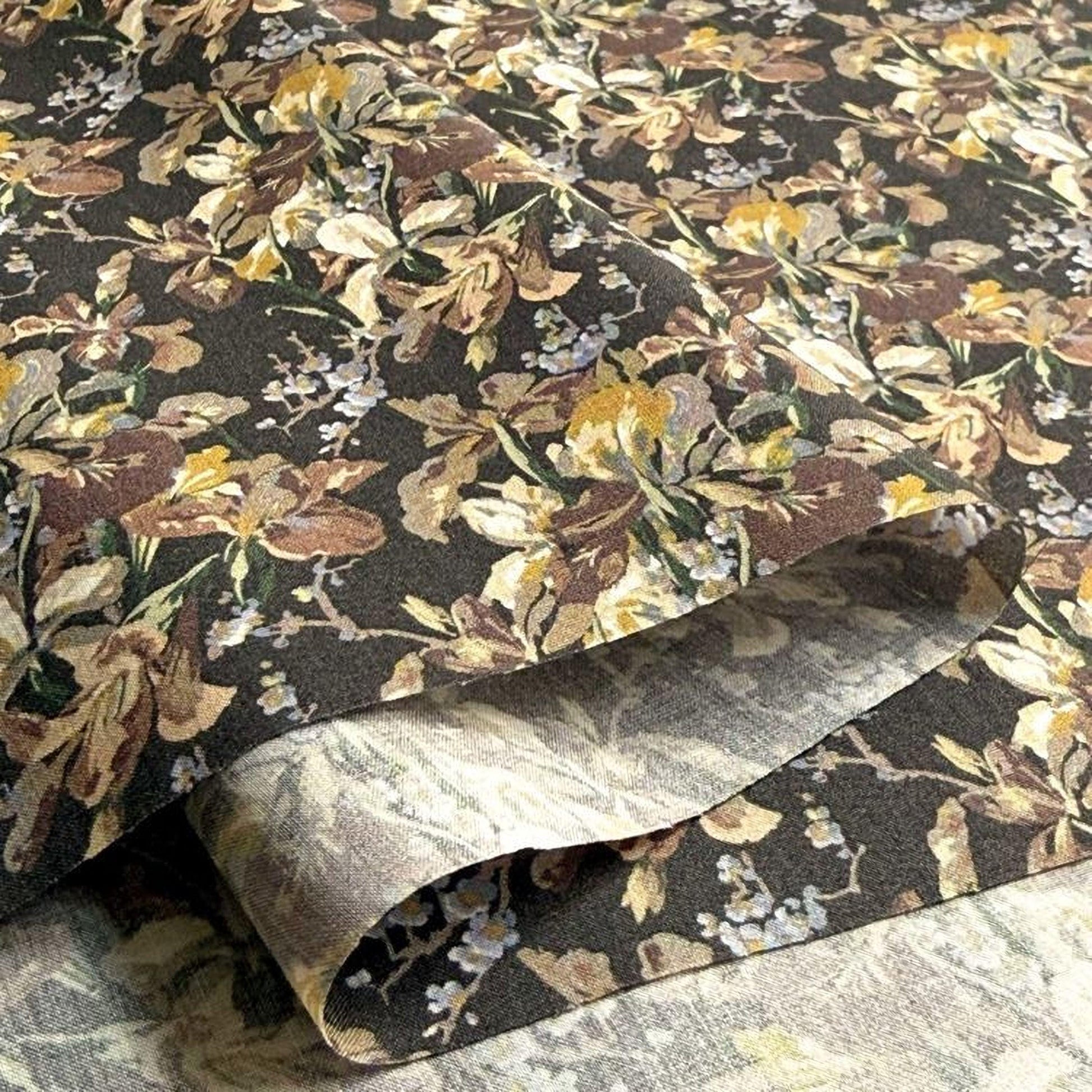a close-up view of a fabric with a floral pattern, featuring a mix of brown, yellow, and white colors. The fabric appears to be made of a material with a textured surface, giving it a unique and visually appealing appearance.